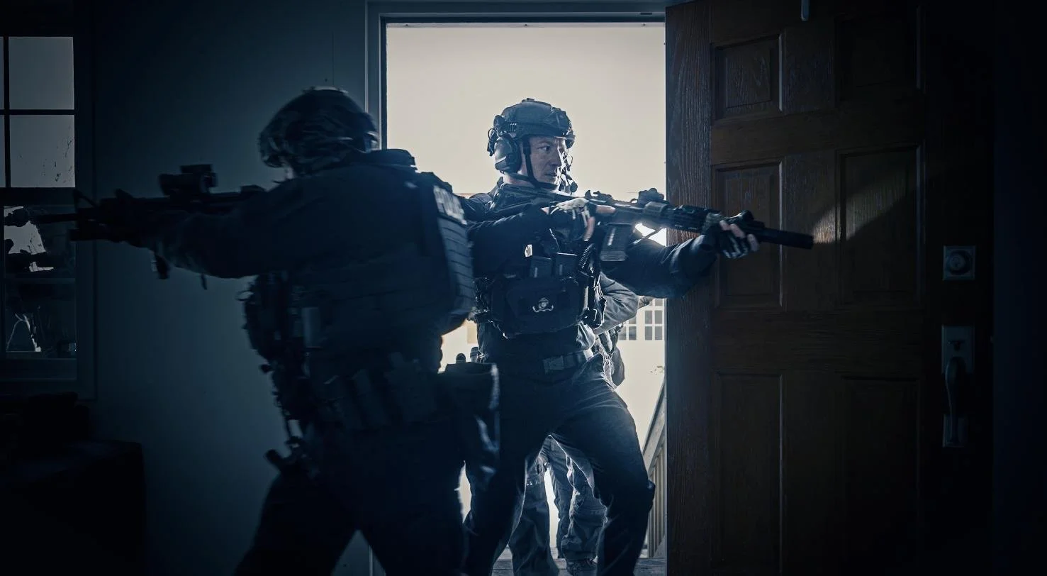 Long Island SWAT Challenge, shot by CXIX: two heavily armed SWAT team members using rifles to breach a door in an indoor setting.