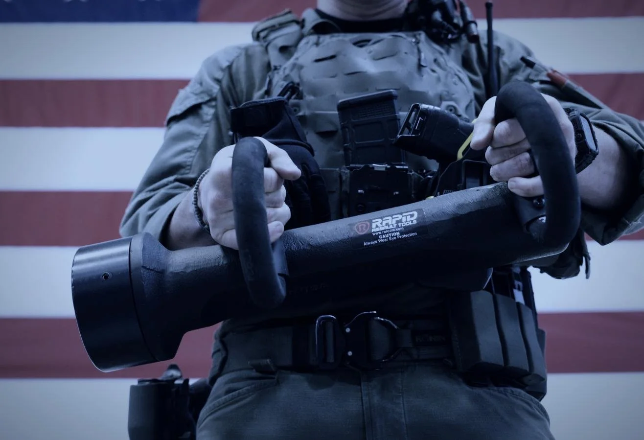 Rapid Assault Tools shoot by CXIX: a person in tactical gear holding a chainsaw with a background of an American flag.