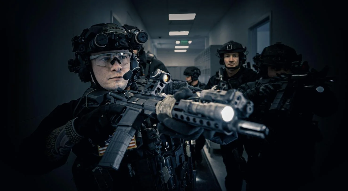 Long Island SWAT Challenge, shot by CXIX: special forces soldiers in tactical gear aiming rifles in a dimly lit hallway.