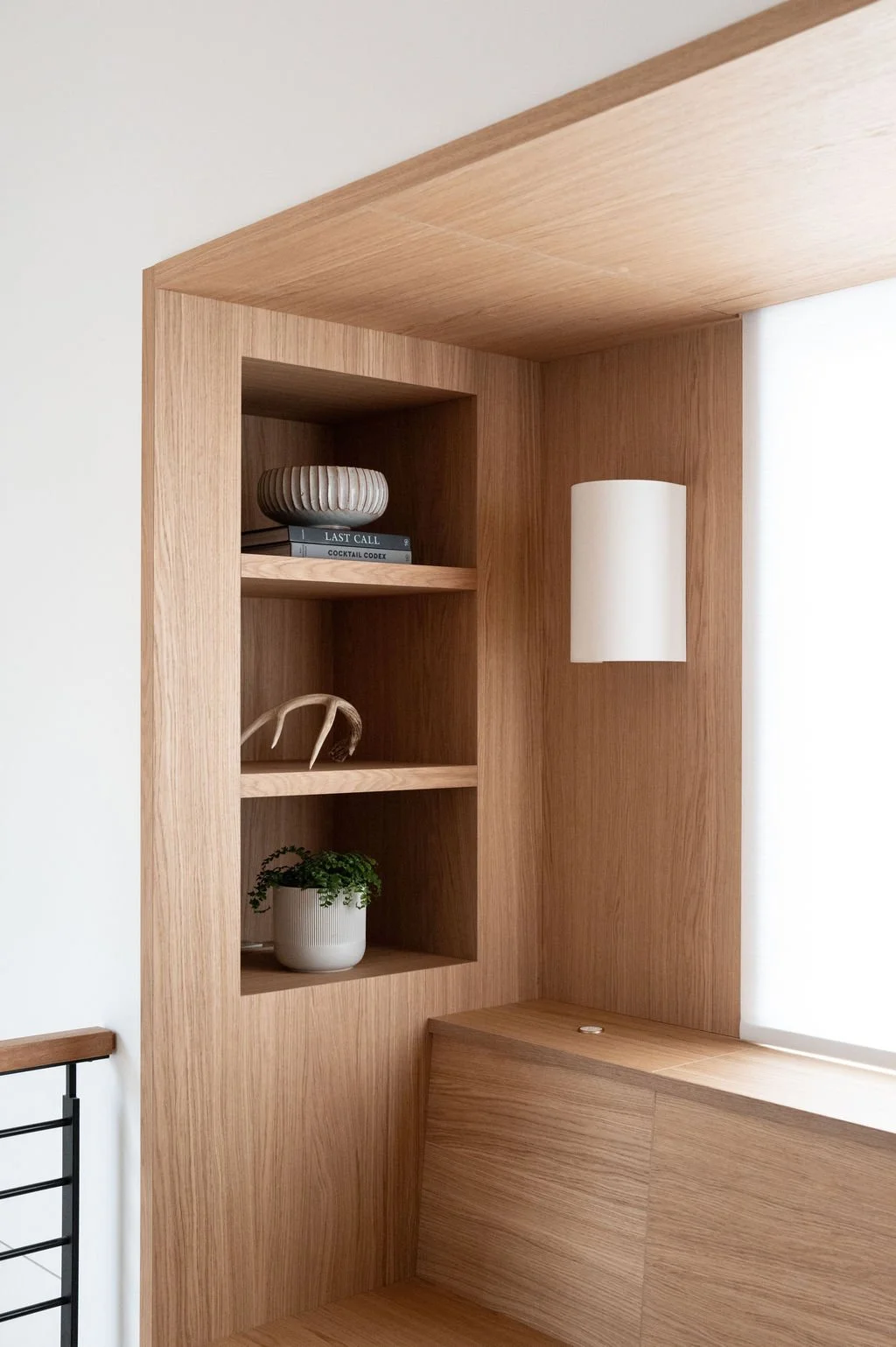 White oak built-in shelving and banquette surround with integrated lighting detail.