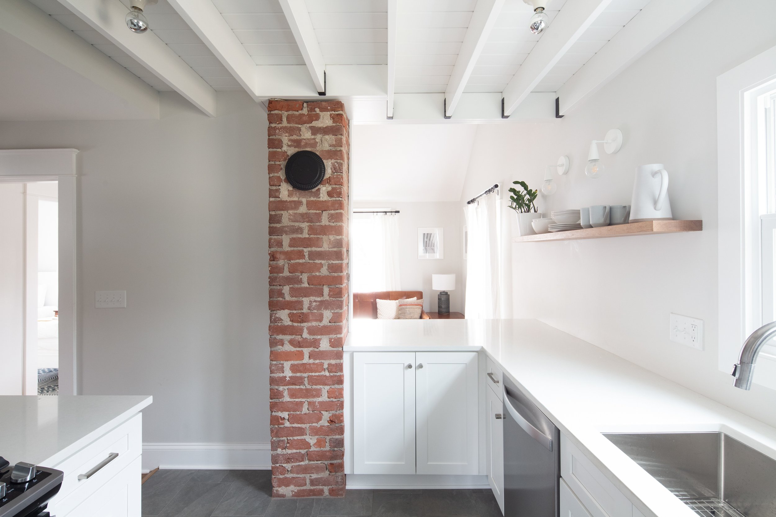 Elevation view of kitchen with exposed ceiling structure and brick mechanical flue.