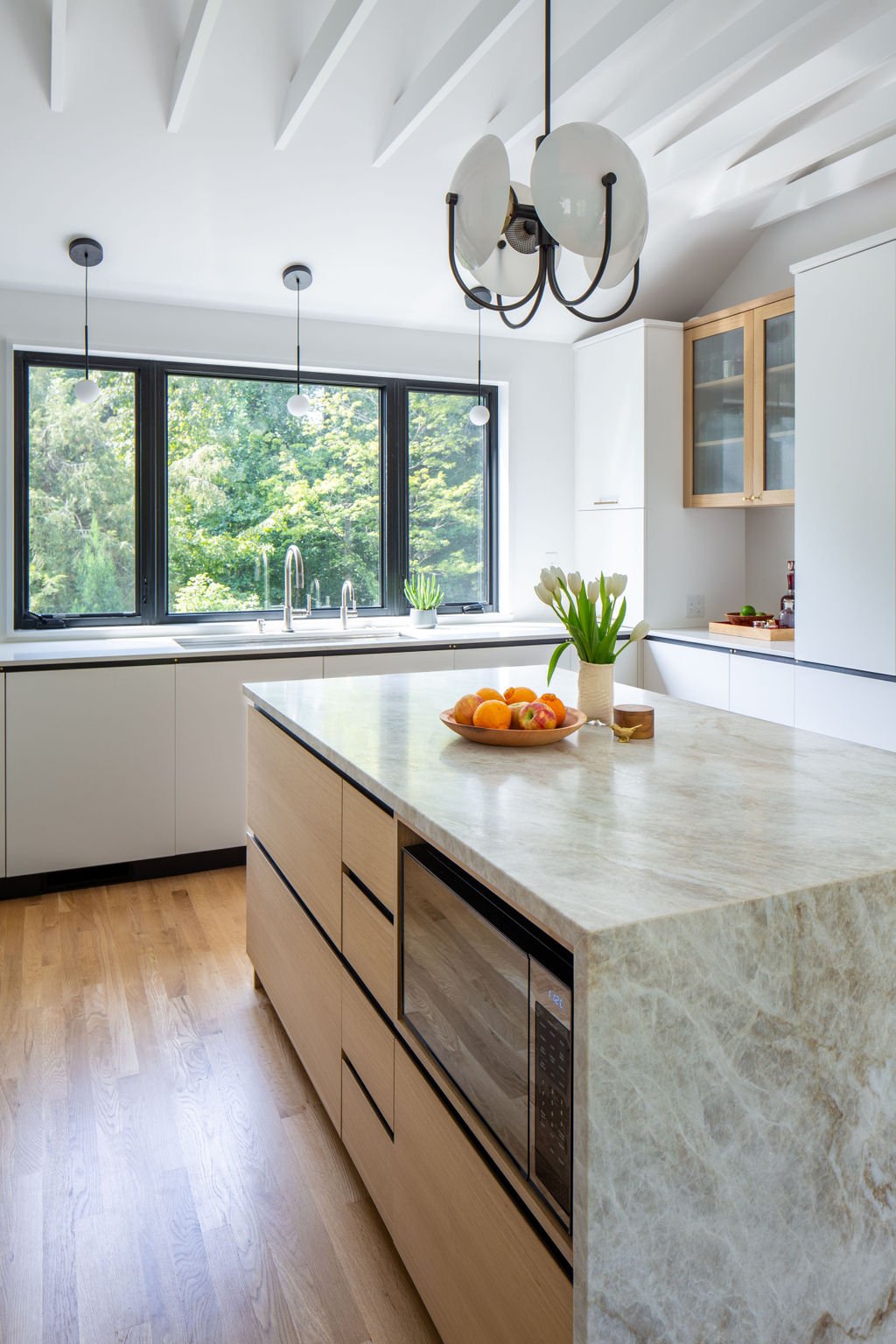Modern kitchen renovation with white oak and painted white cabinetry with integral hardware in Charlottesville VA.
