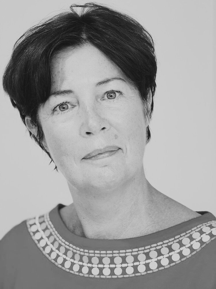 Black and white portrait of a woman with short dark hair, light skin, and wearing a top with a patterned neckline.