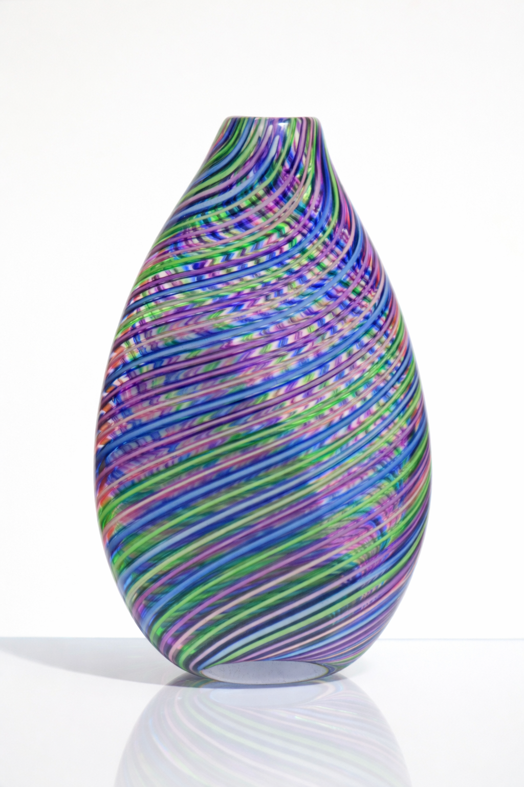 Colorful glass vase with swirling multicolored stripes on a white background.