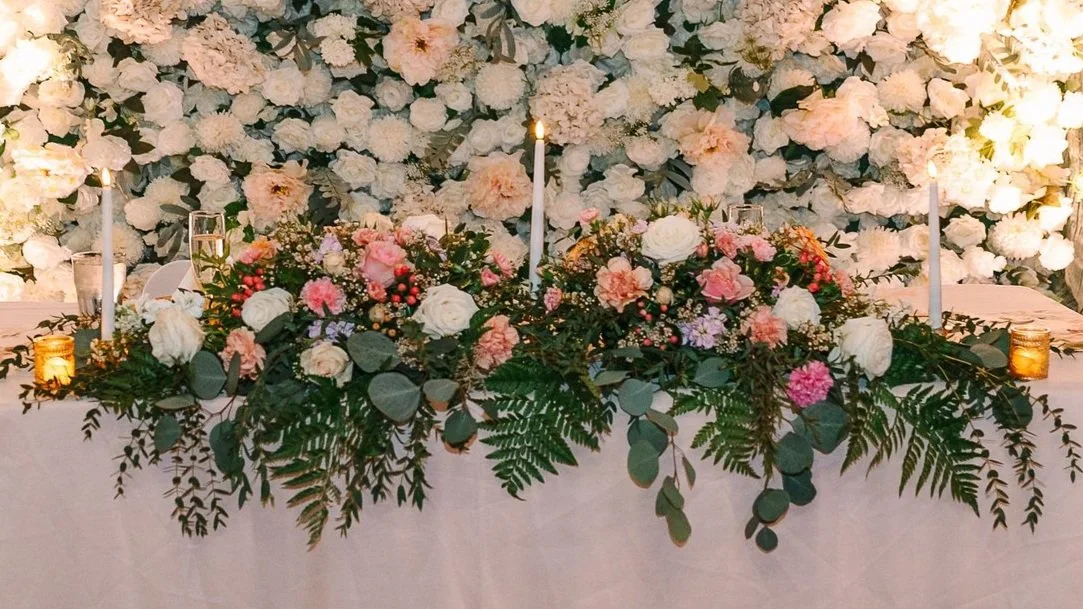 Floral wedding table centerpiece with candles and greenery