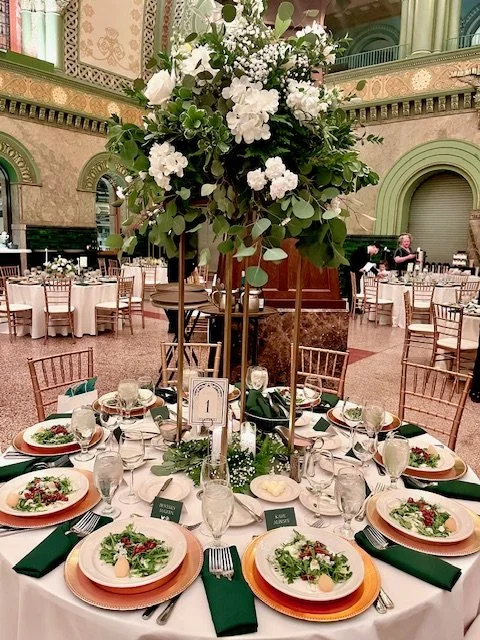 Green and white accent blooms on a hold harlow stand.