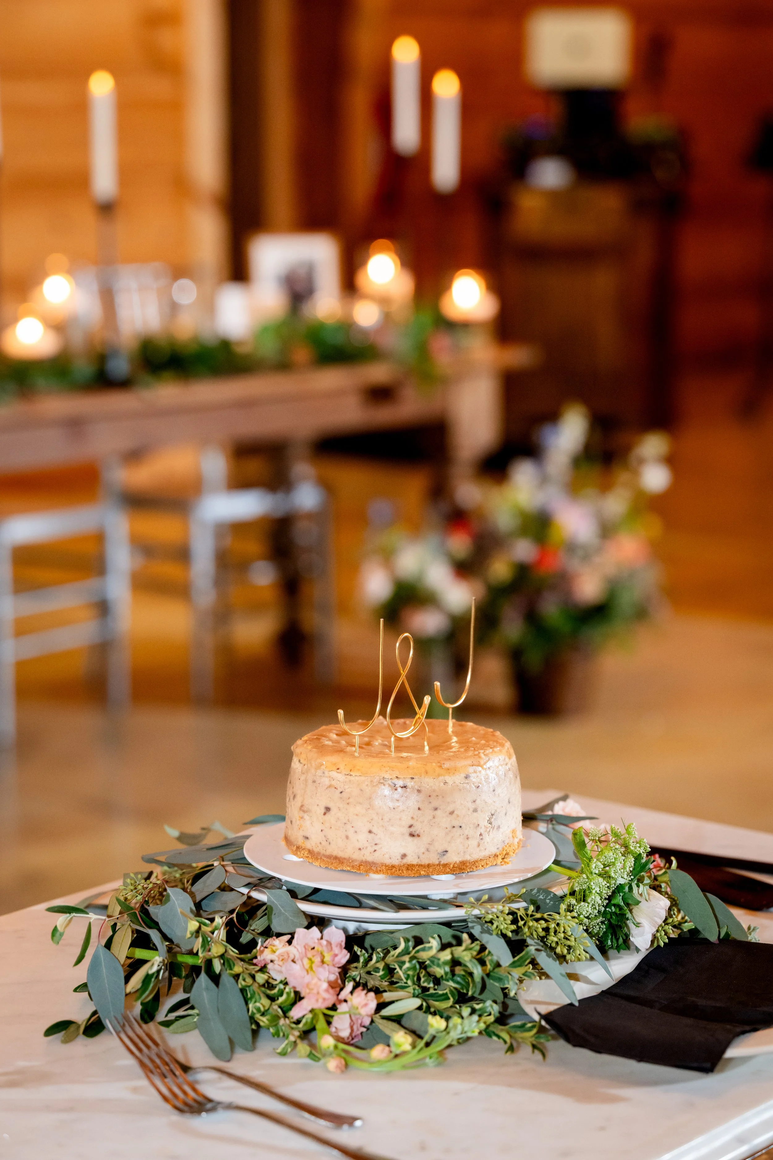 Greenery and tucks blooms around base of cake.