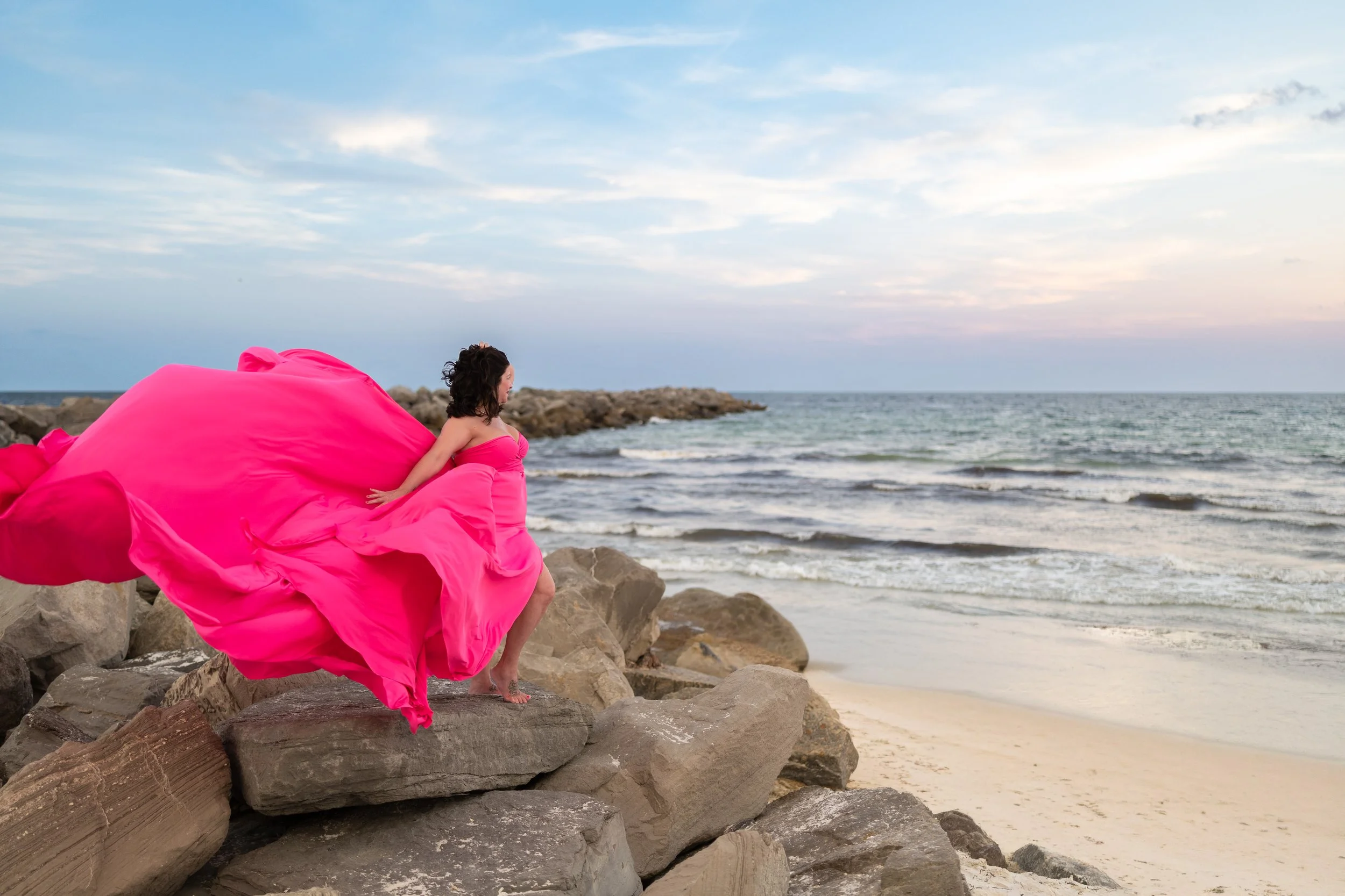 Hot pink flying dress on jetties rocks Florida