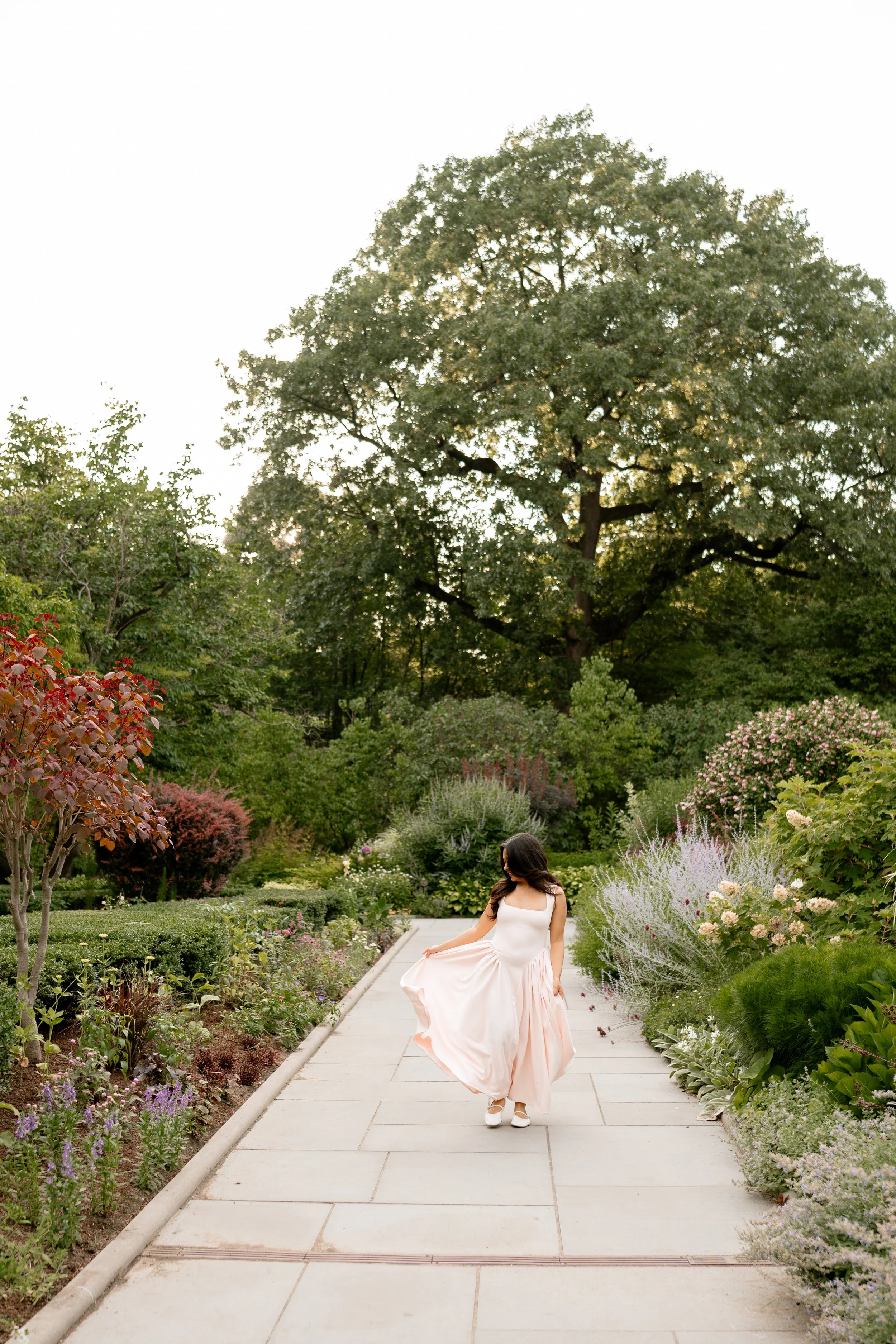 Calista Hennie, standing on a garden pathway in Central Park.