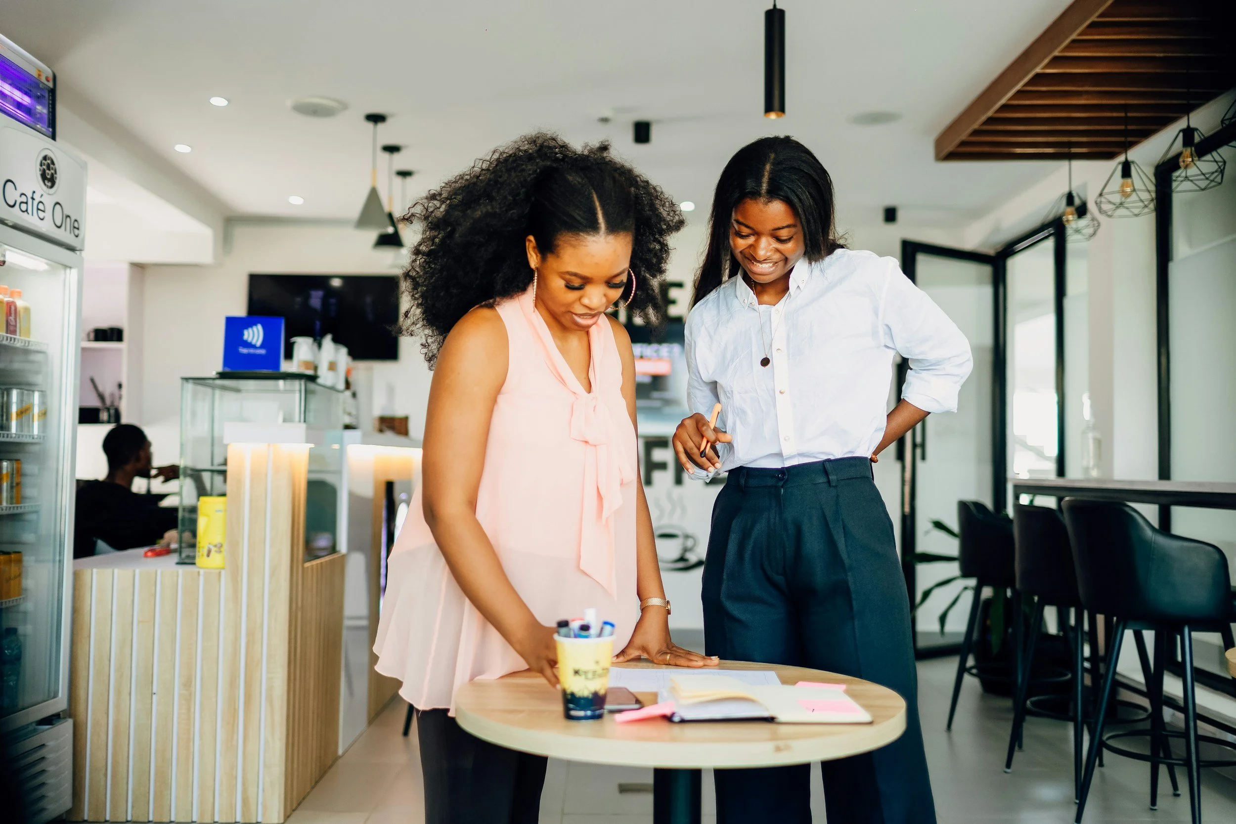 An HR professional having a supportive conversation with a pregnant employee in a modern workplace, representing maternity support before going on leave.