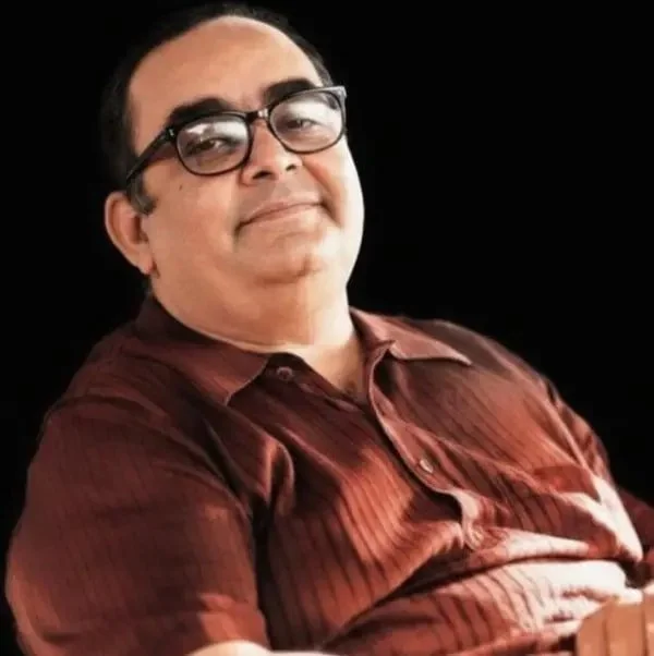 Retrato de Antonio Blay con gafas sobre fondo oscuro.