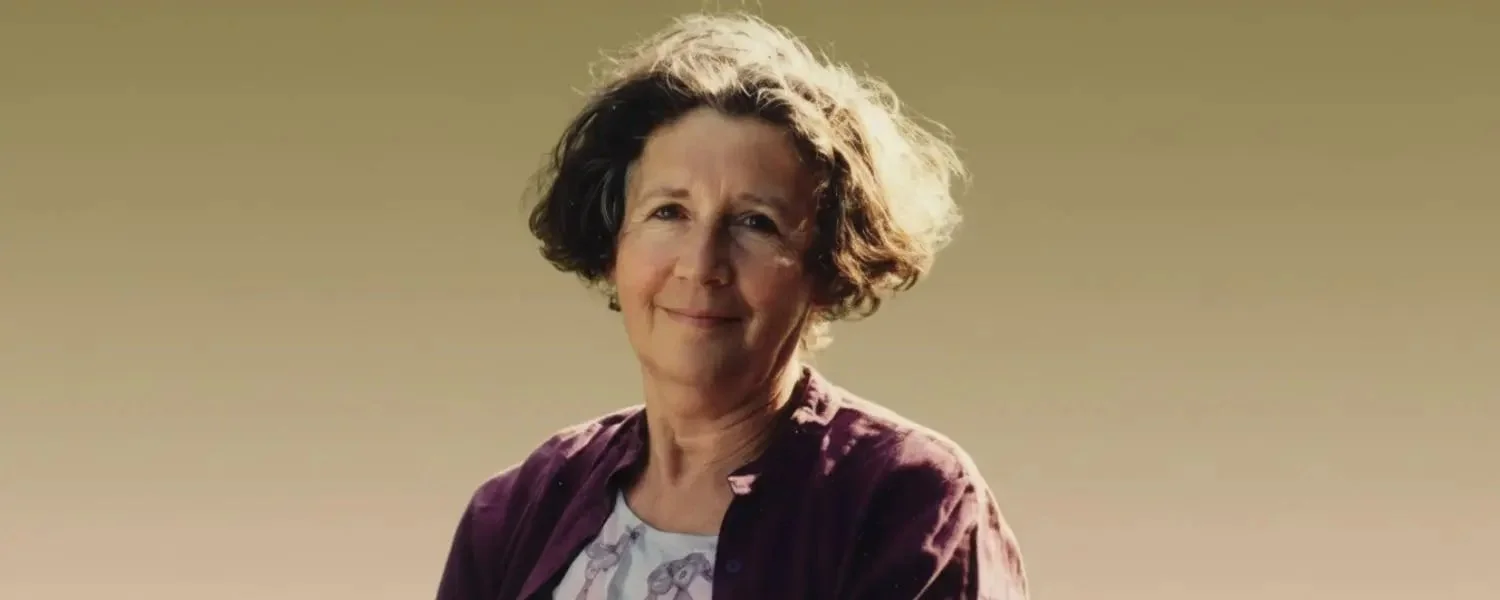 Retrato de Alice Miller con luz cálida sobre fondo neutro.