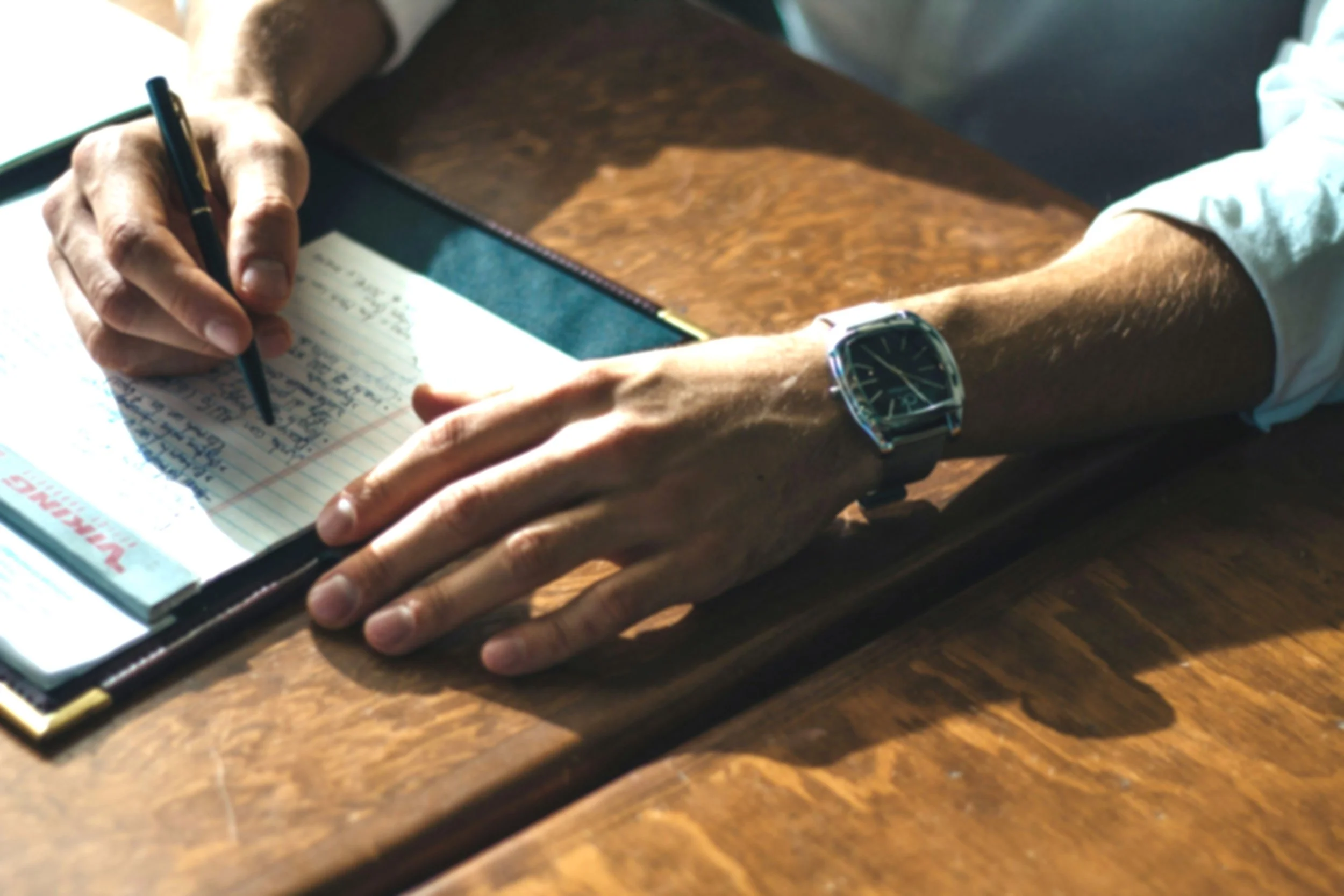 Homebuyer signing a real estate purchase and sale agreement during a property transaction.