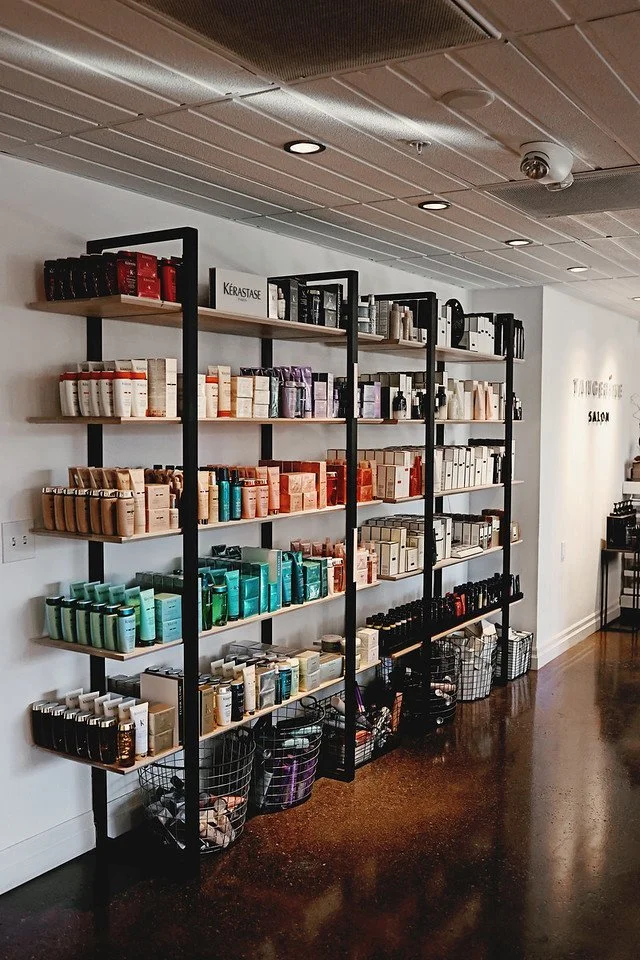 Interior of a hair salon product shelf with hair products from kerastase and oribe with a white background