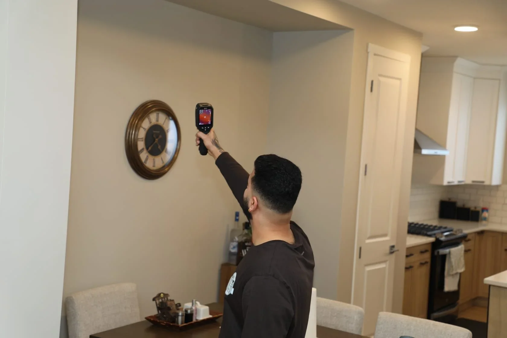 Navv Parmar using a thermal imaging camera to detect heat loss and hidden issues inside a residential property