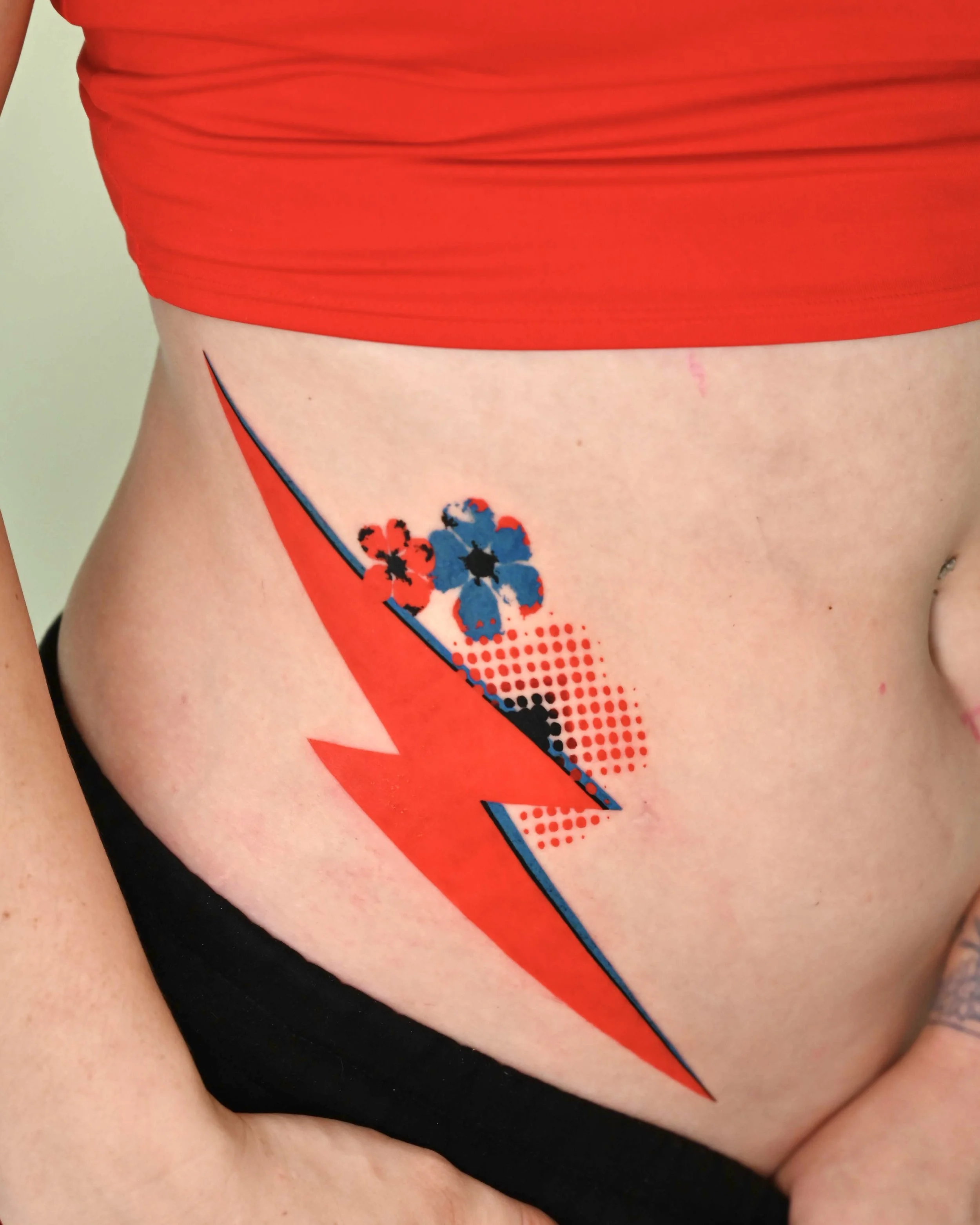 Red lightning bolt side tattoo with blue flowers by Megink.