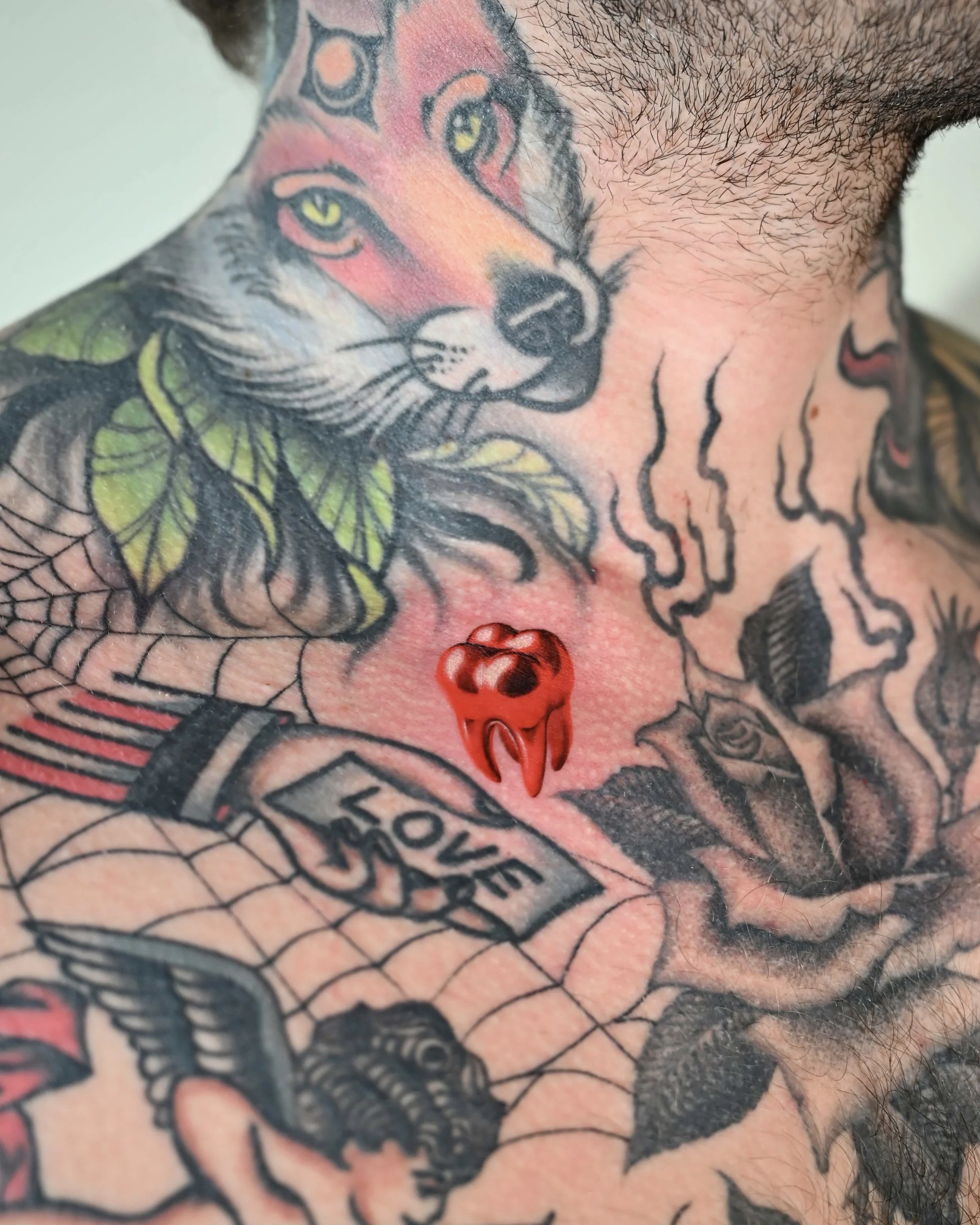 Wolf face neck tattoo with red chrome tooth by Megink.