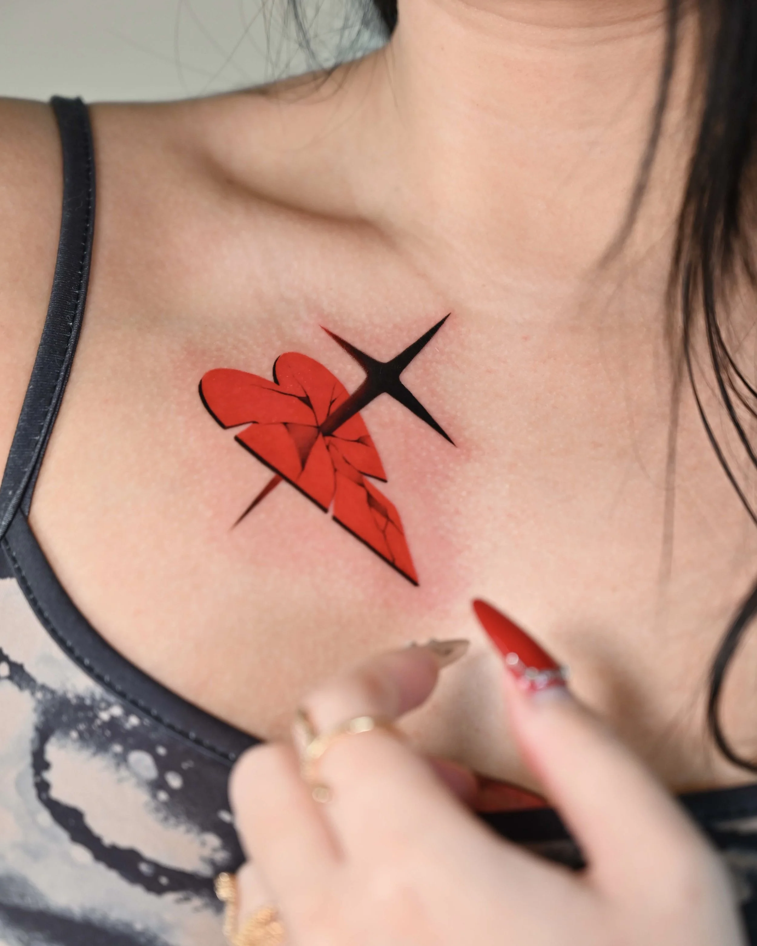 Red heart and dagger chest tattoo with black star by Megink.