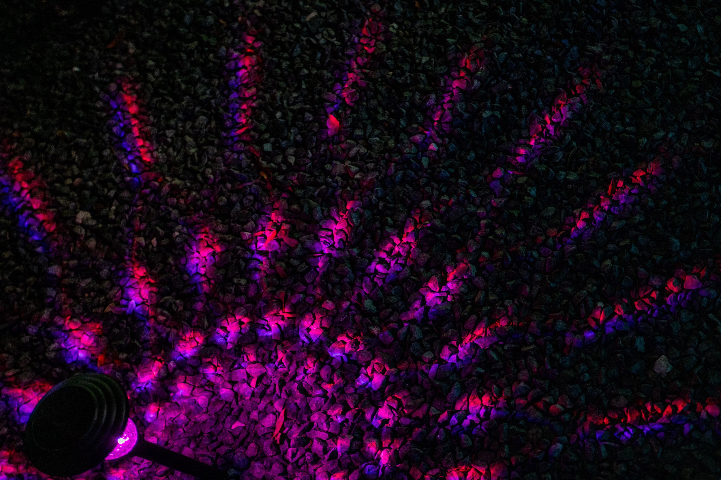 Colorful lights casting patterns on rocks