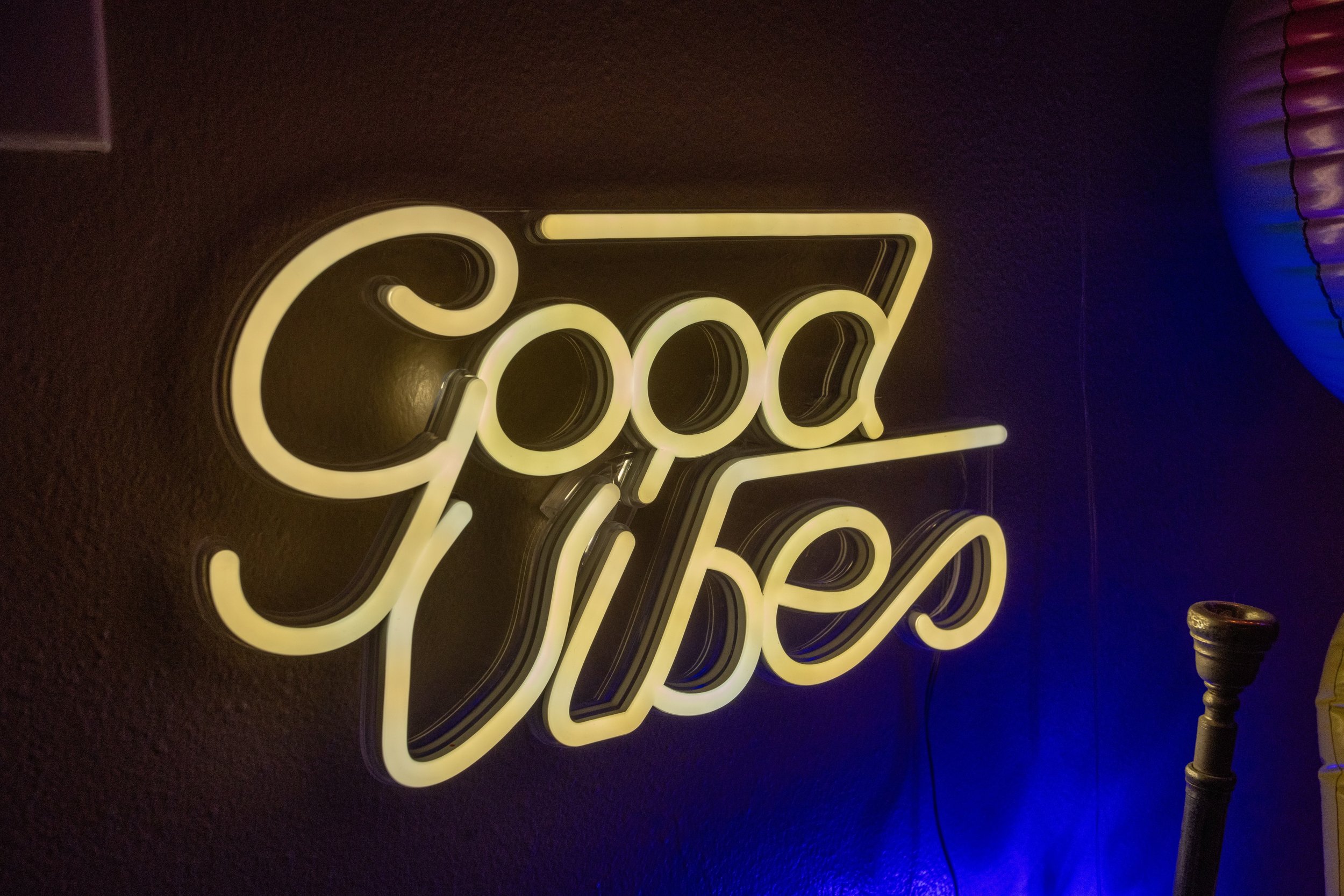 Neon sign displaying 'Good Vibes' on a dark wall