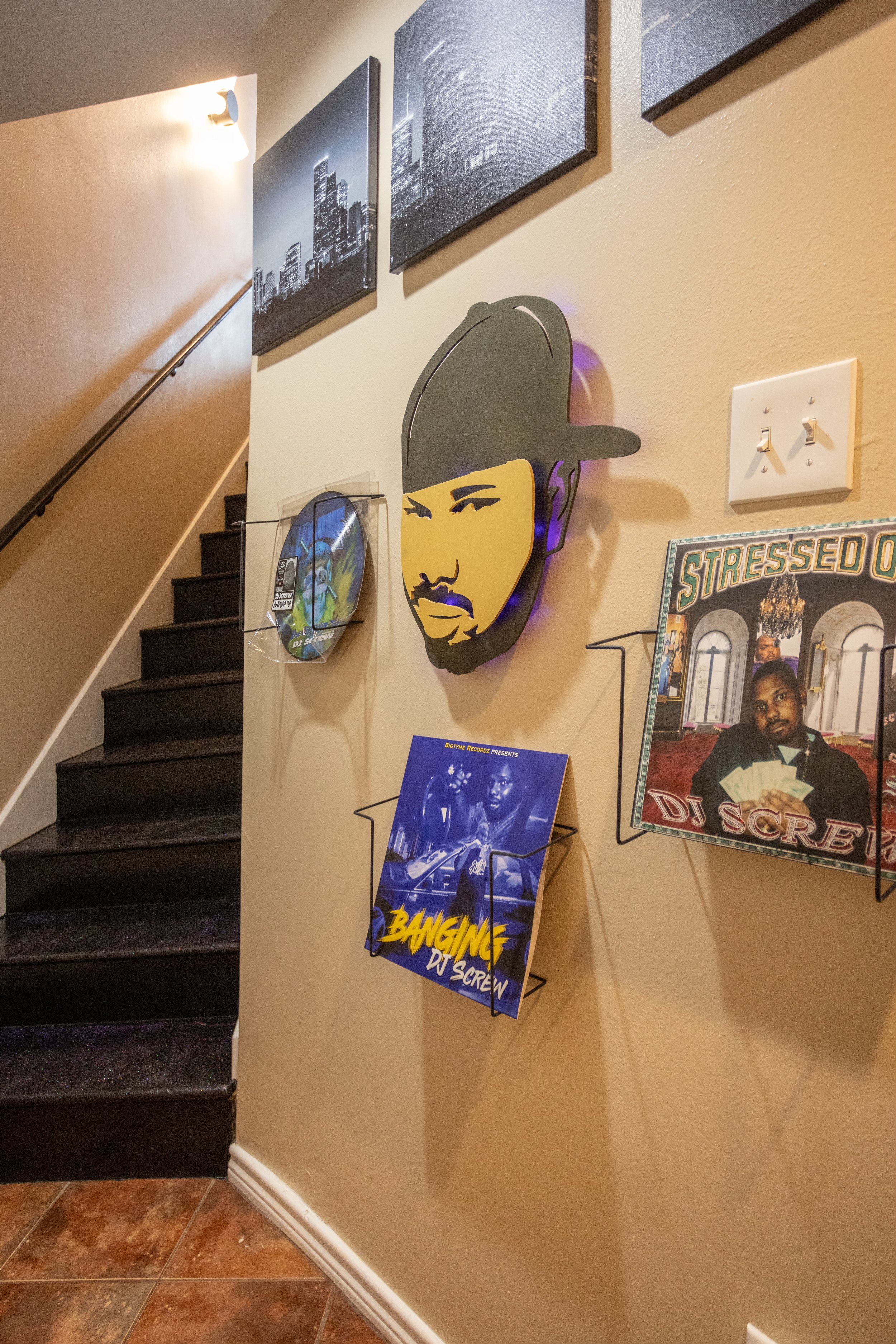 Stairway with music-themed wall art, including portraits and vinyl records, featuring a DJ theme.