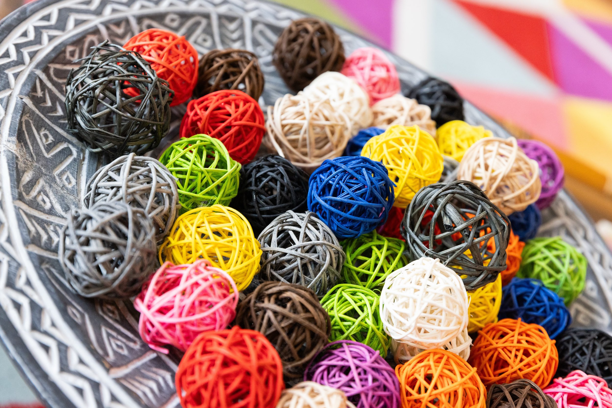 Colorful woven string balls in a decorative dish