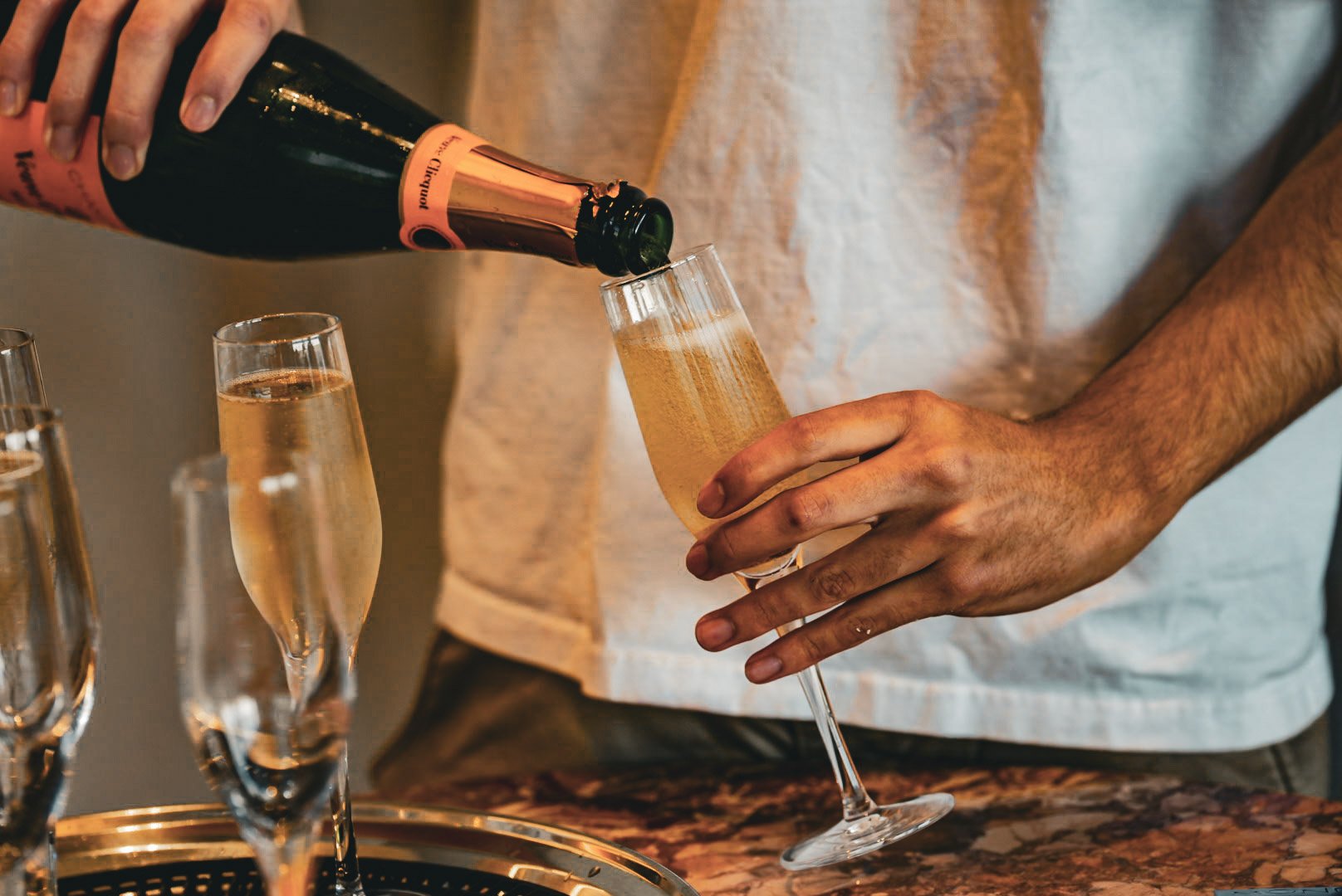 Person pouring champagne into a flute glass at celebration or gathering