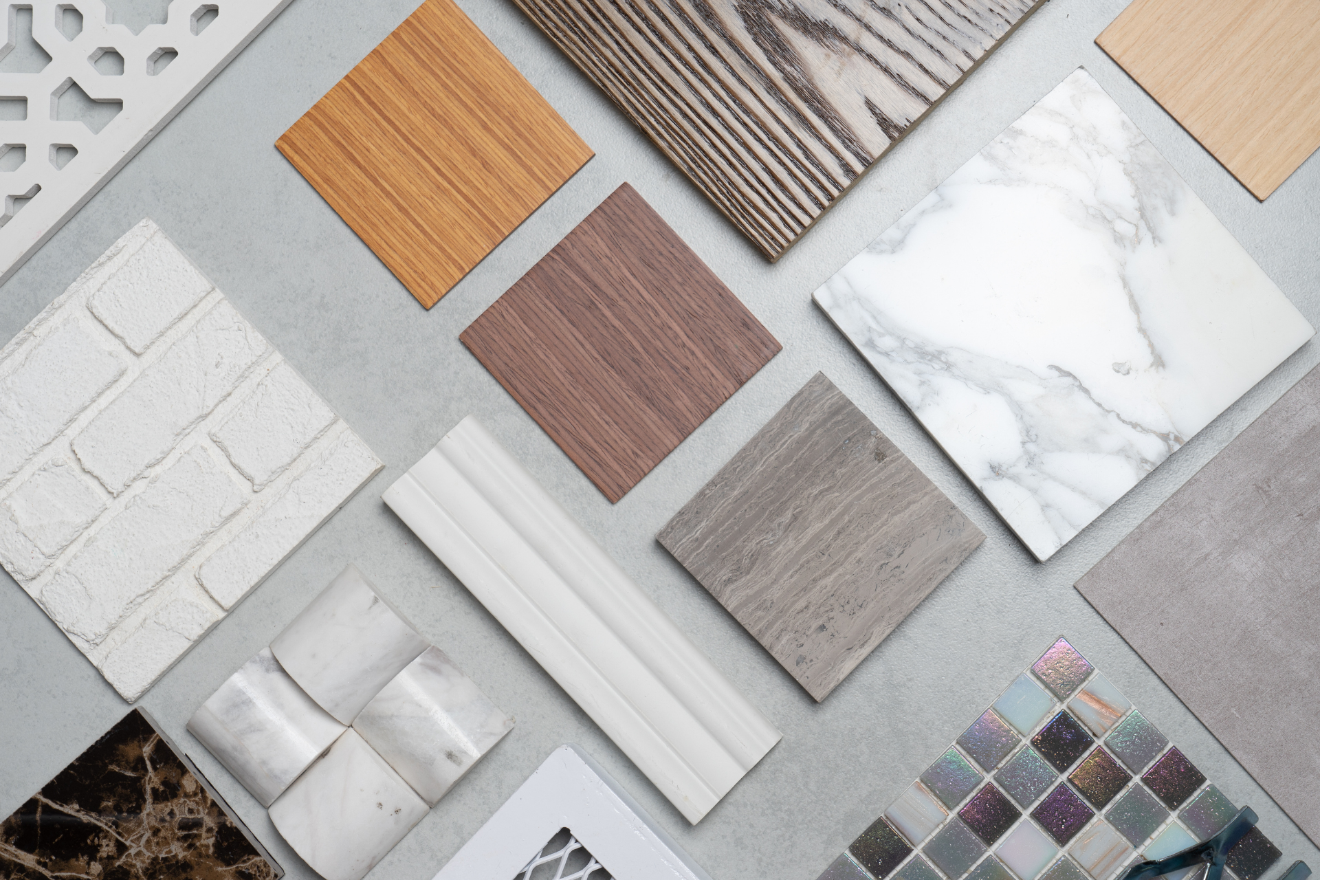 Selection of timber, stone, tile and other building material samples arranged on a surface.
