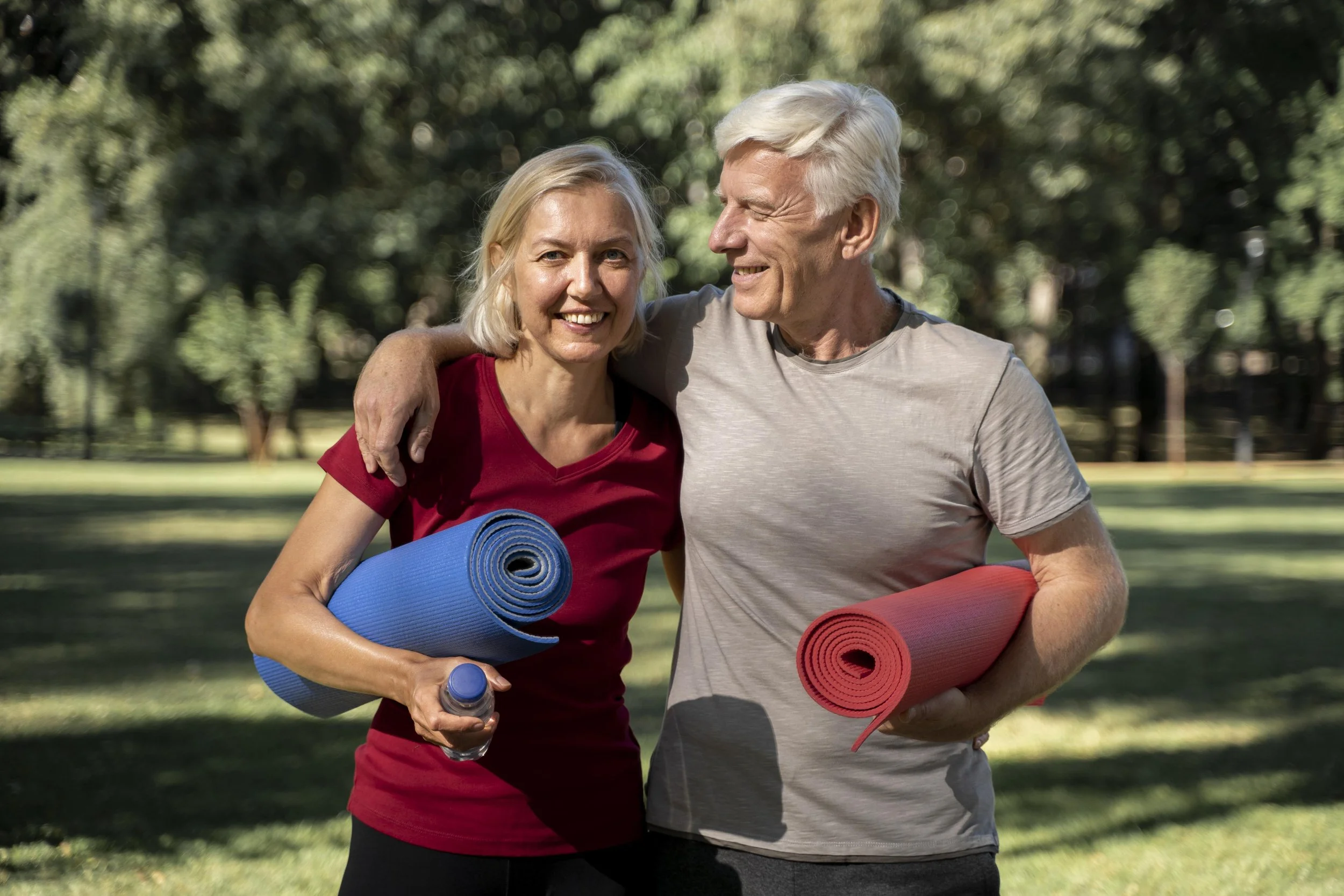 smiley-elder-couple-outdoors-with-yoga-mats-water-bottle.jpg