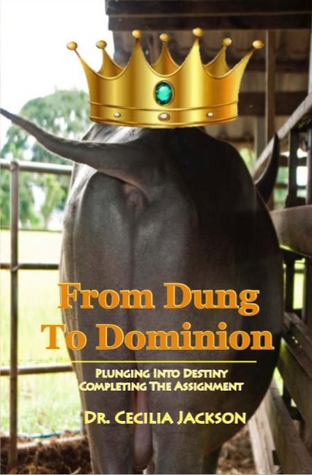 A cow standing in a barn, with a digitally added crown on its rear end. The text reads "From Dung to Dominion: Plunging into Destiny Completing the Assignment" by Dr. Cecilia Jackson.