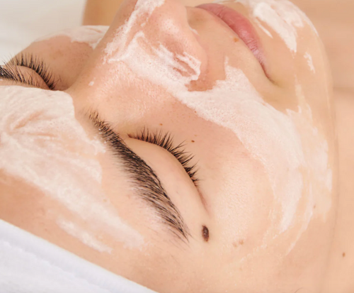 women with white bubbles on face from facial