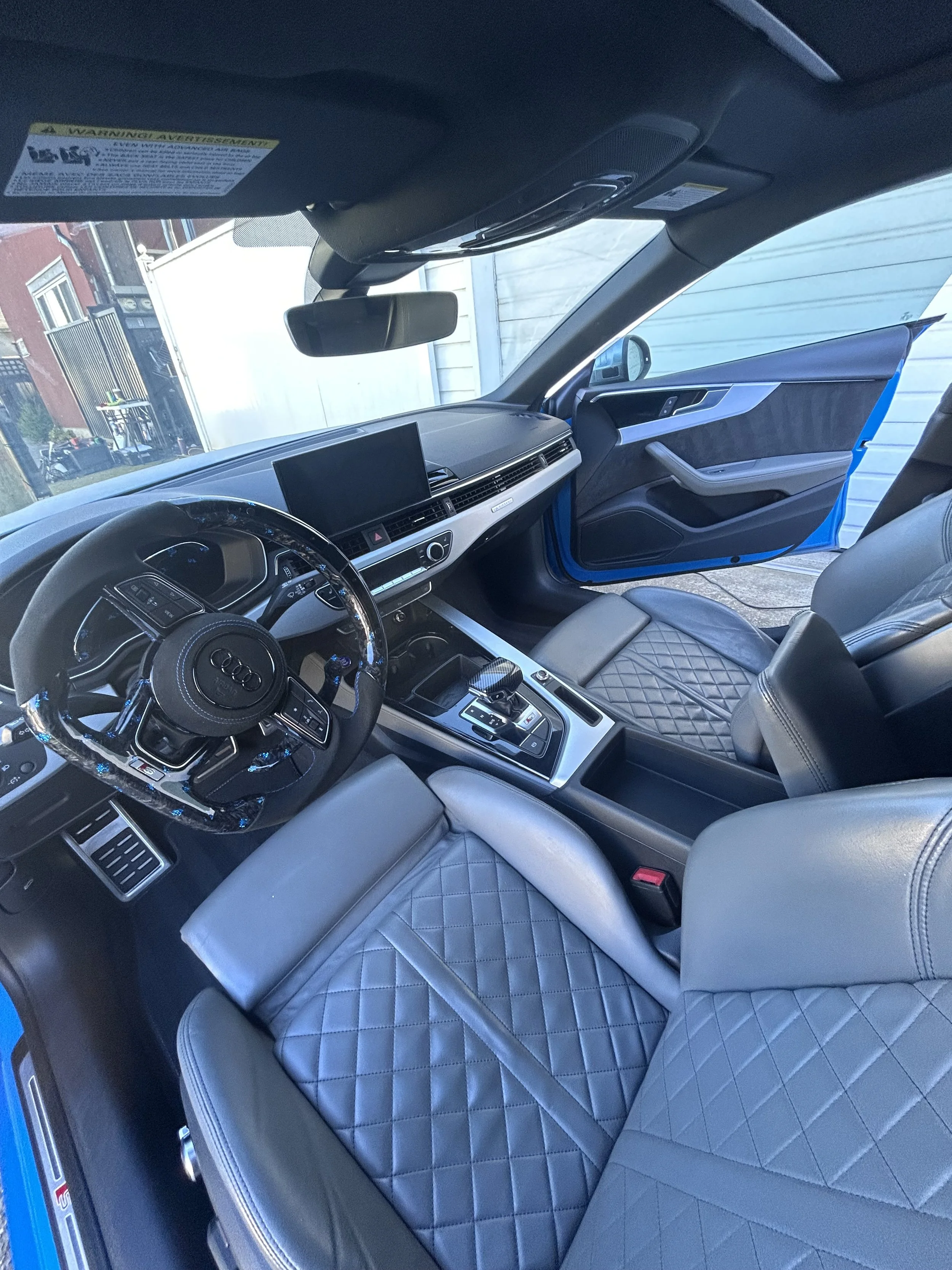 Luxury car interior with quilted leather seats and modern dashboard design.