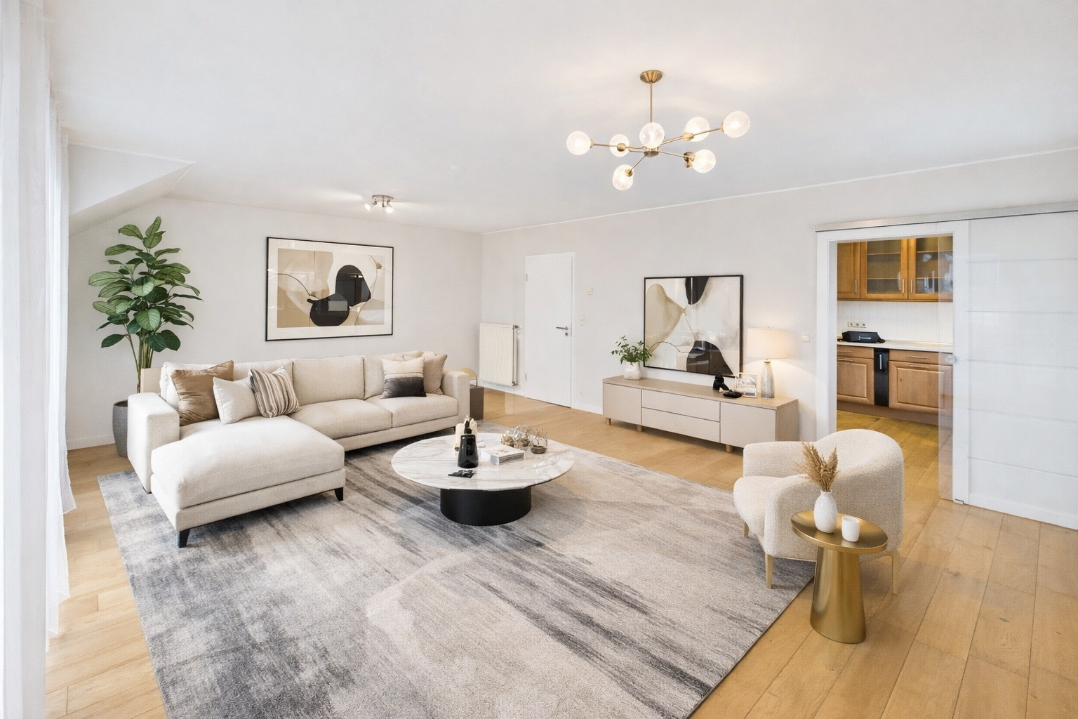 Salon moderne avec canapé beige, tapis gris, meuble TV blanc, tableau abstrait, lampes, plante verte et fauteuil beige avec table d'appoint