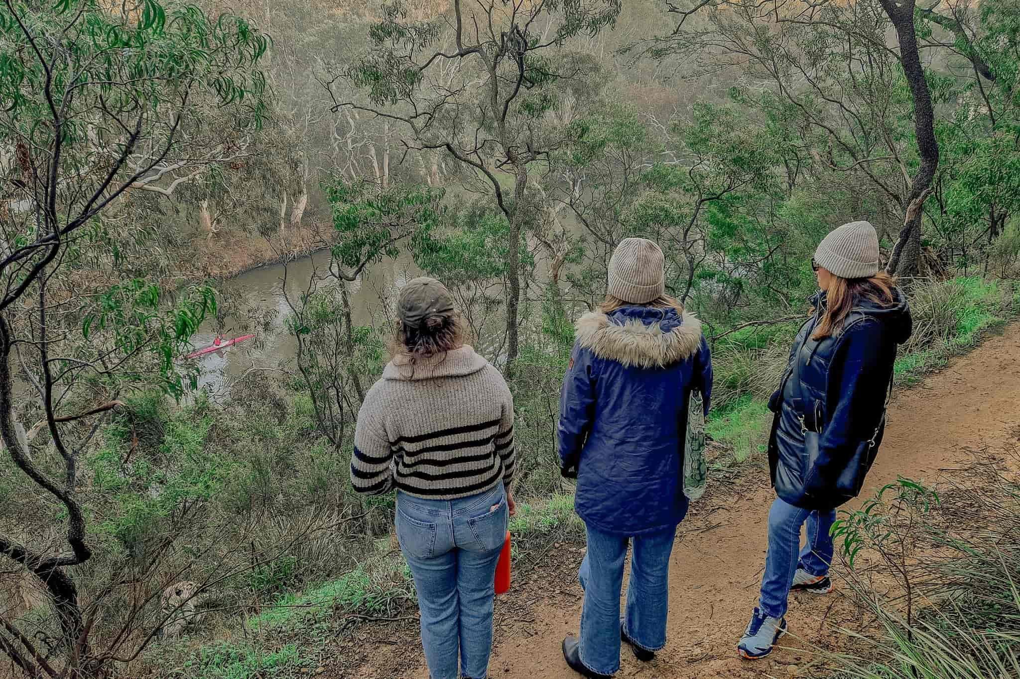 visitors looking at the yarra river from the trail and spotting a kayak