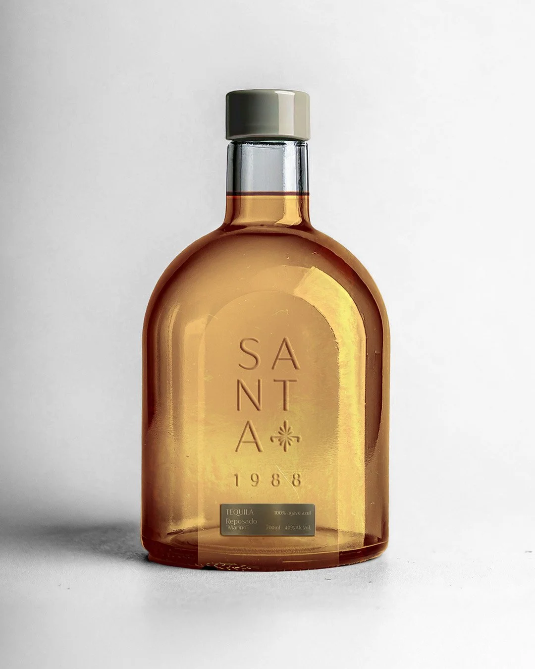 Bottiglia di tequila Santa 1988 Reposado Marino, corpo senape, tappo grigio, su sfondo bianco.