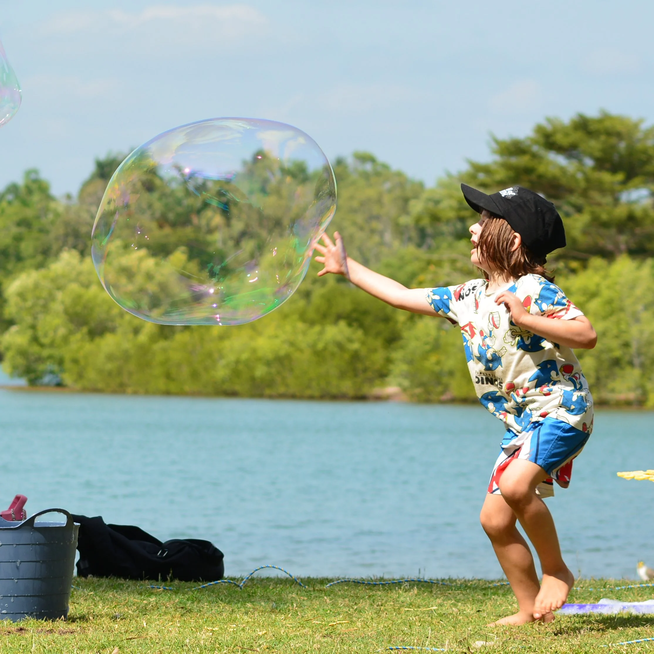 Child popping bubble - Bubble Birthday Party at Lake Alexander 2024