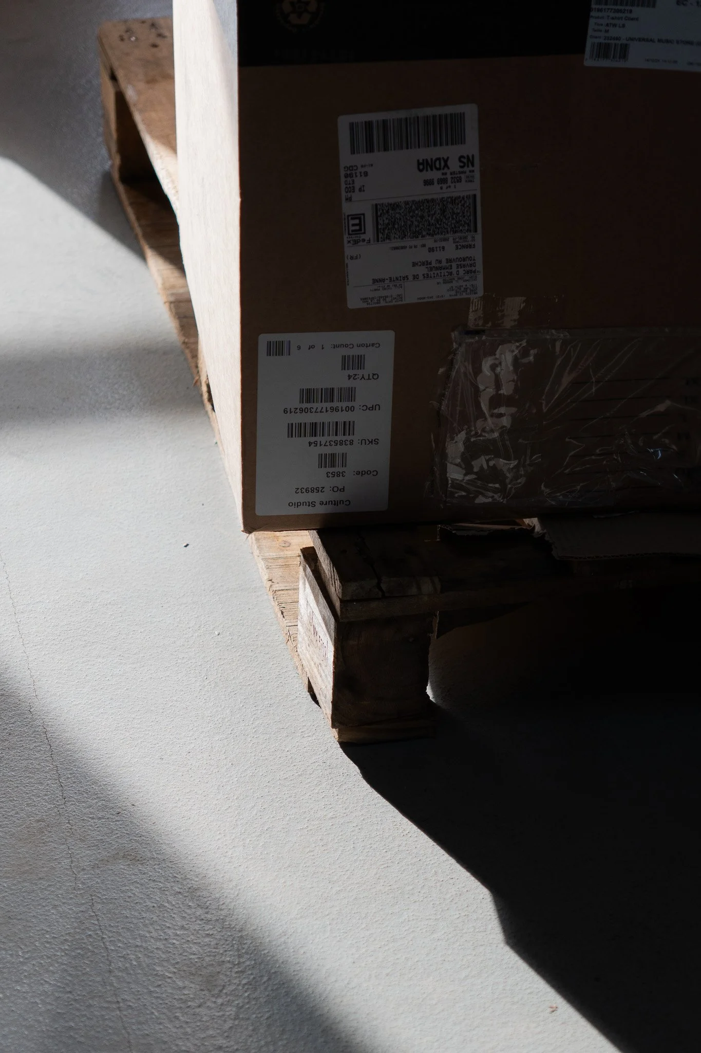 Un carton en bois posé sur un plateau en bois, avec des étiquettes d'expédition, dans un espace bien éclairé.