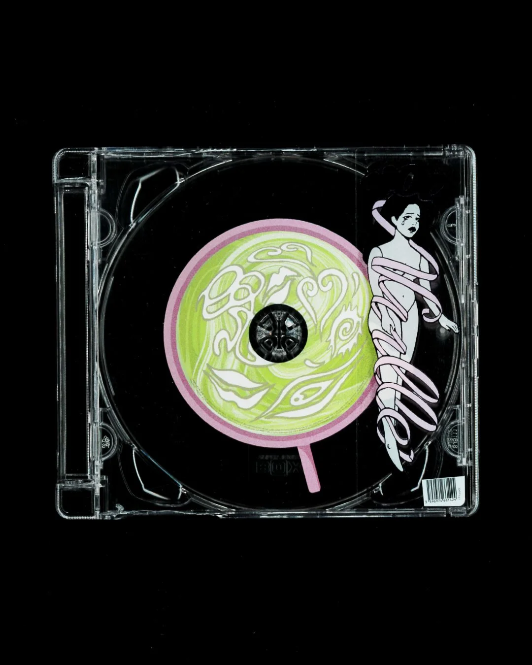 Coffret CD avec une illustration d'une femme sur la jaquette et un motif rose et vert en forme de visage avec un smiley, sur fond noir.