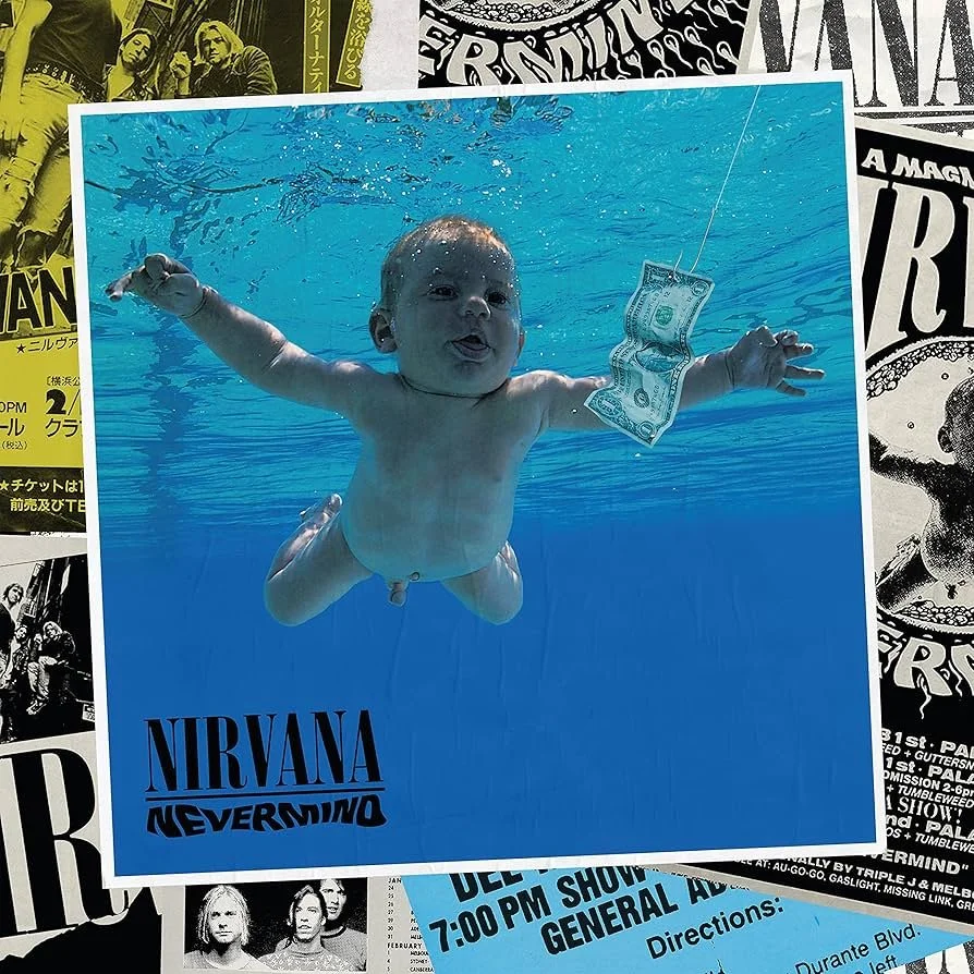 Une affiche de Nirvana Nevermind avec une image d'un bébé nageant sous l'eau, parmi d'autres affiches et flyers en arrière-plan.