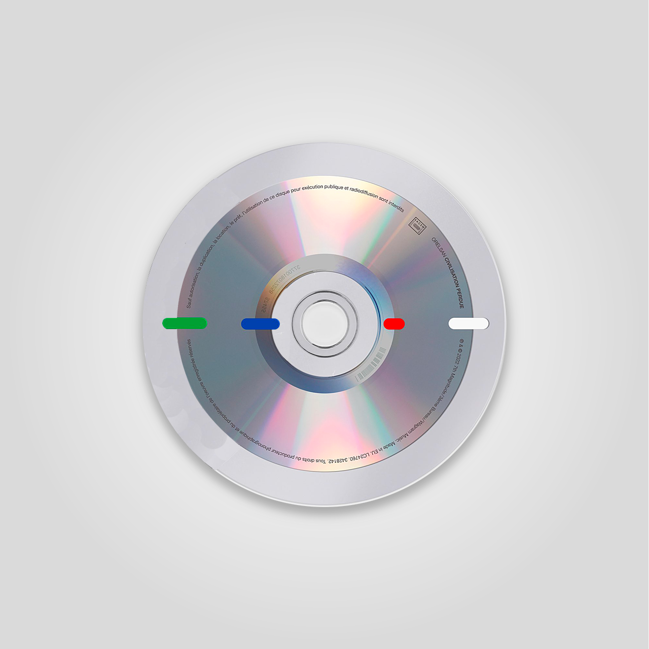 Un disque compact placé au centre d'un fond gris clair, avec des marques de couleur (vert, bleu, rouge, blanc) et du texte imprimé autour de sa surface.