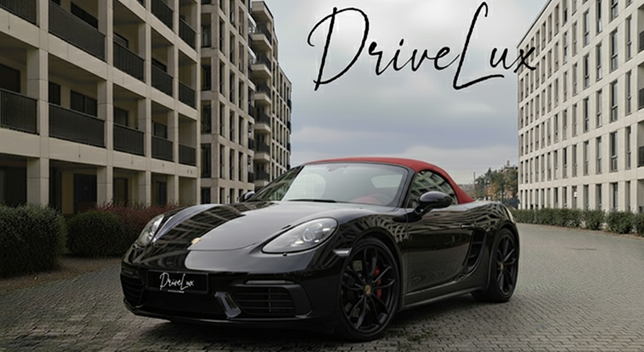 Une voiture de sport noire avec un toit rouge dans une rue urbaine, avec le texte "DriveLux" en haut à droite.