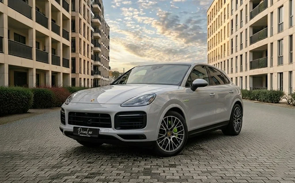 Trois voitures de sport Porsche en rouge, bleu et violet dans un hangar avec deux avions privés en arrière-plan.