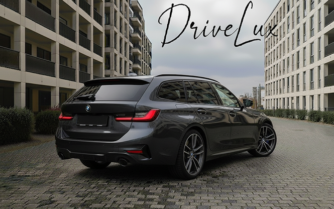 Une voiture BMW bleue devant un avion léger blanc à l'atterrissage sur une piste d'aéroport, avec un paysage verdoyant à l'arrière-plan.