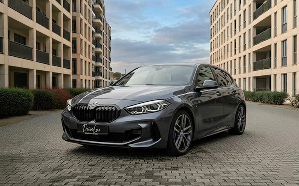 Une petite voiture bleue garée devant un hangar contenant des avions jaunes de voltige.