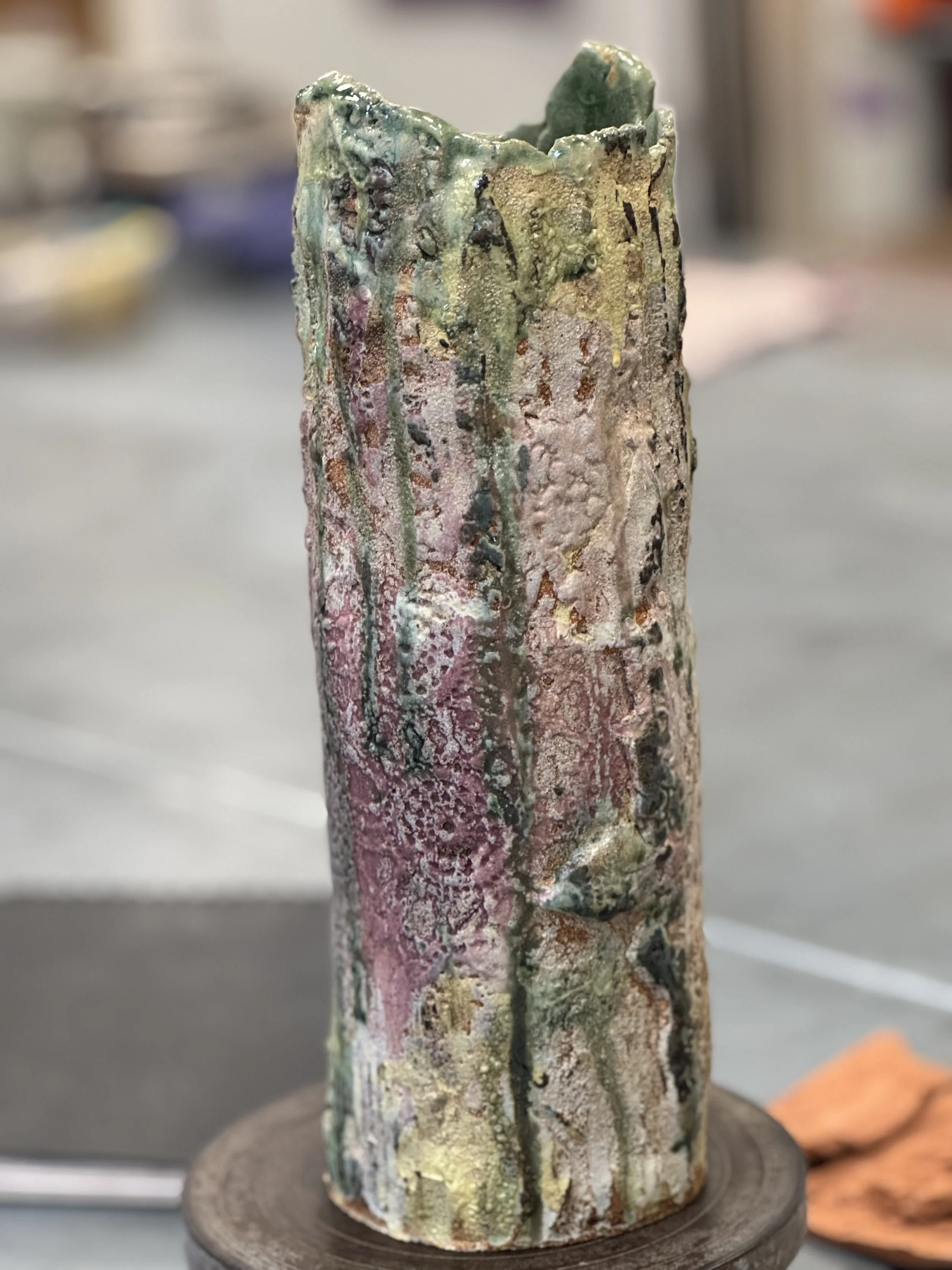 Handbuilt tall stoneware vase with textured surface.