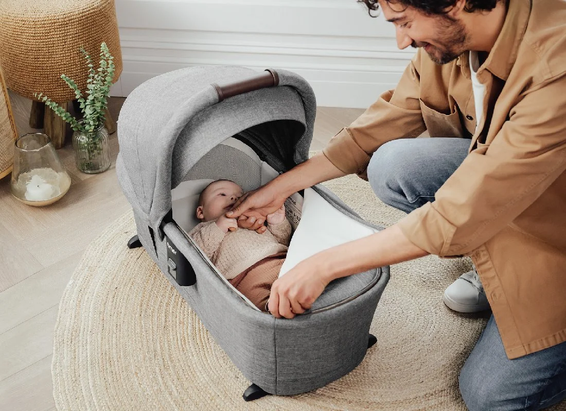 Man zipping up the foot cover on sera bassinet.jpg