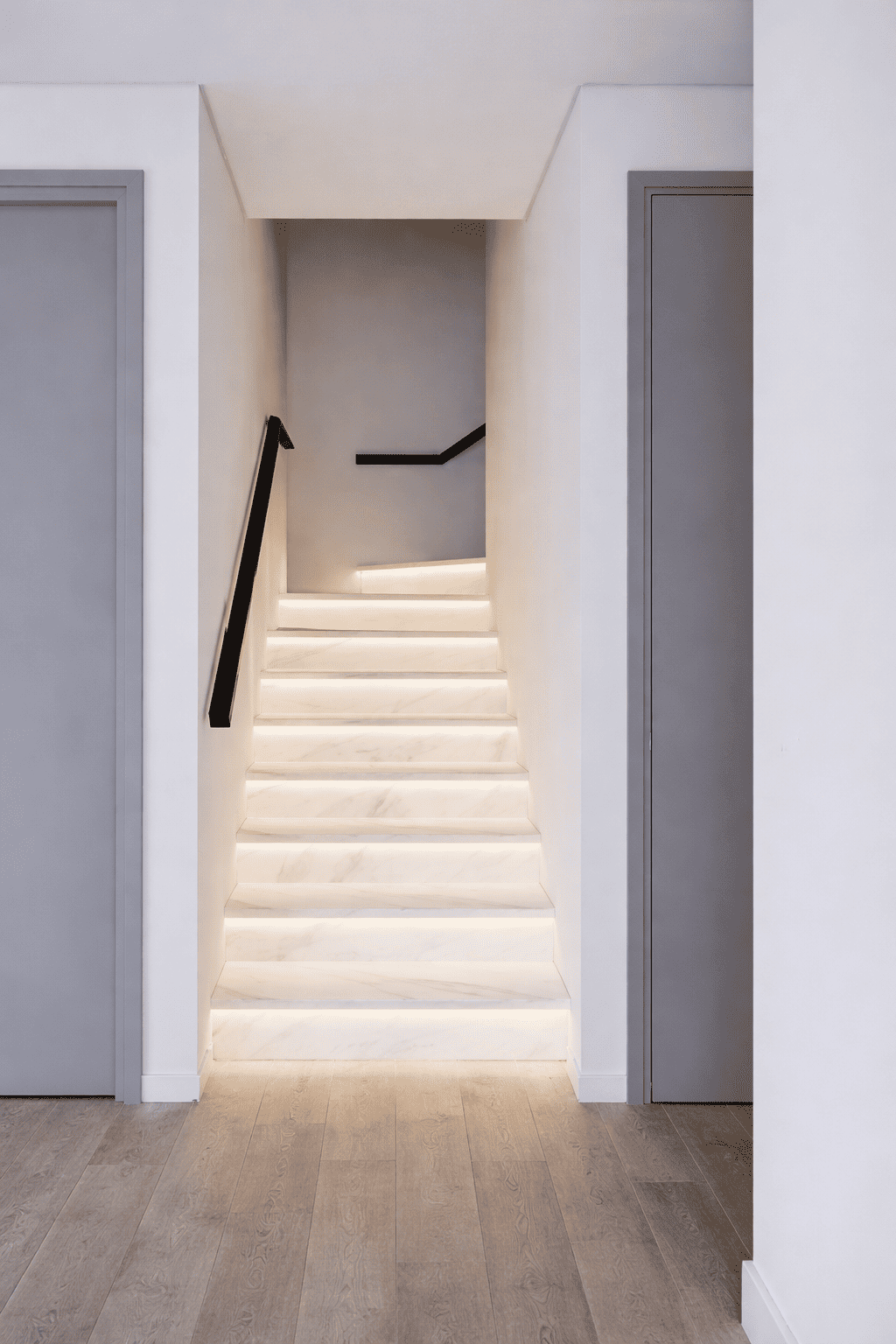 Illuminated marble staircase in minimalistic hallway.png