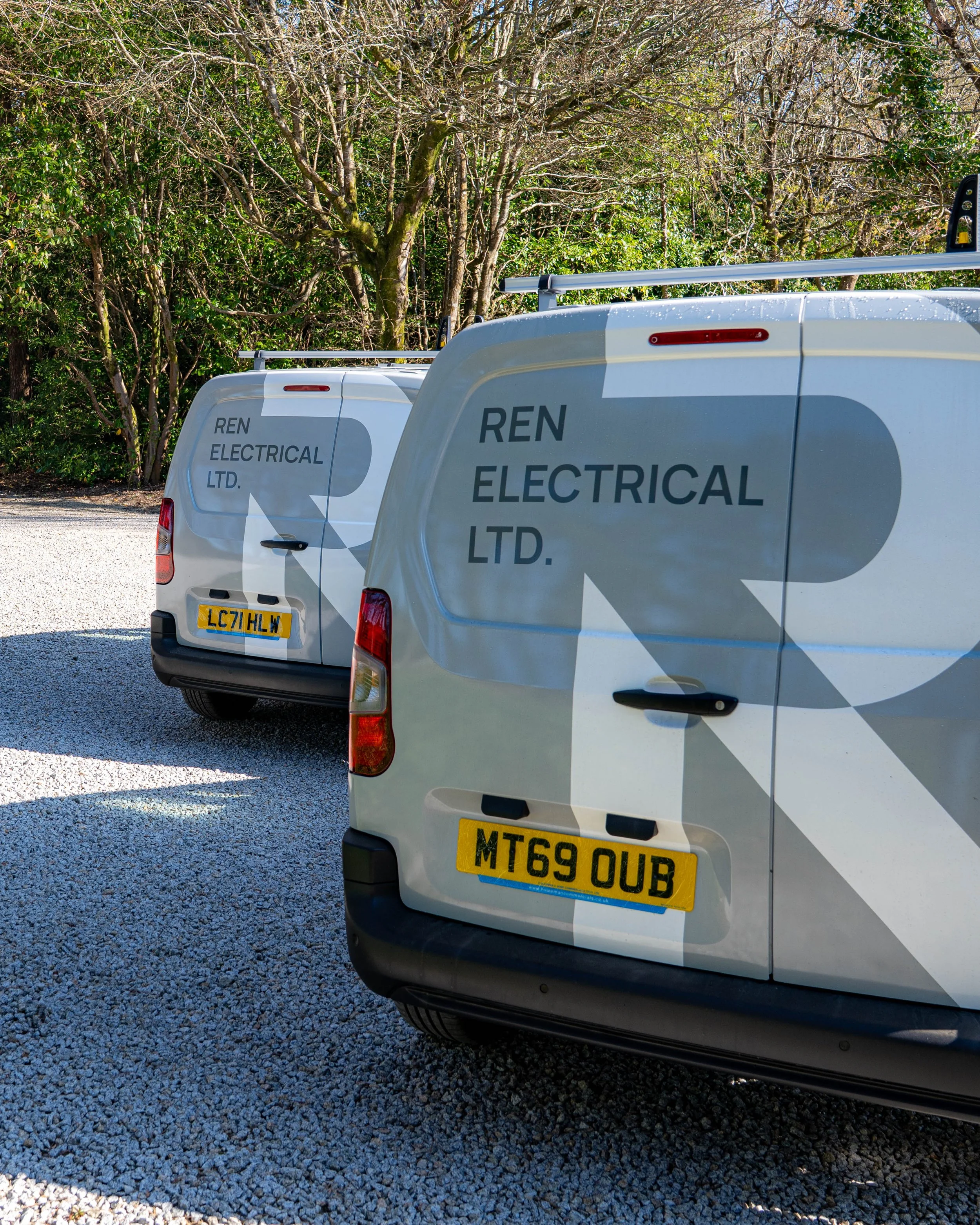 Two vans outside in the sun with REN Electrical branding