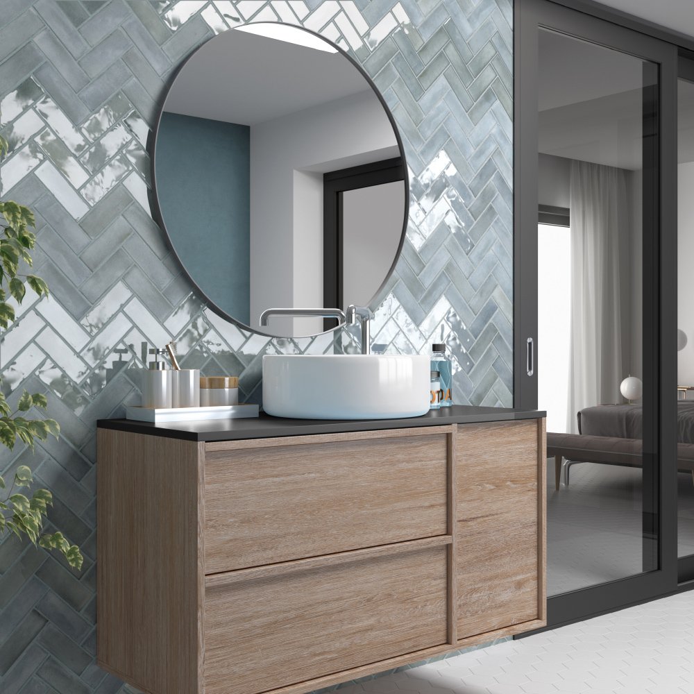 Modernes Badezimmer mit rundem Spiegel, Holzwaschtisch, Waschbecken und Kacheln in Fischgrätmuster.