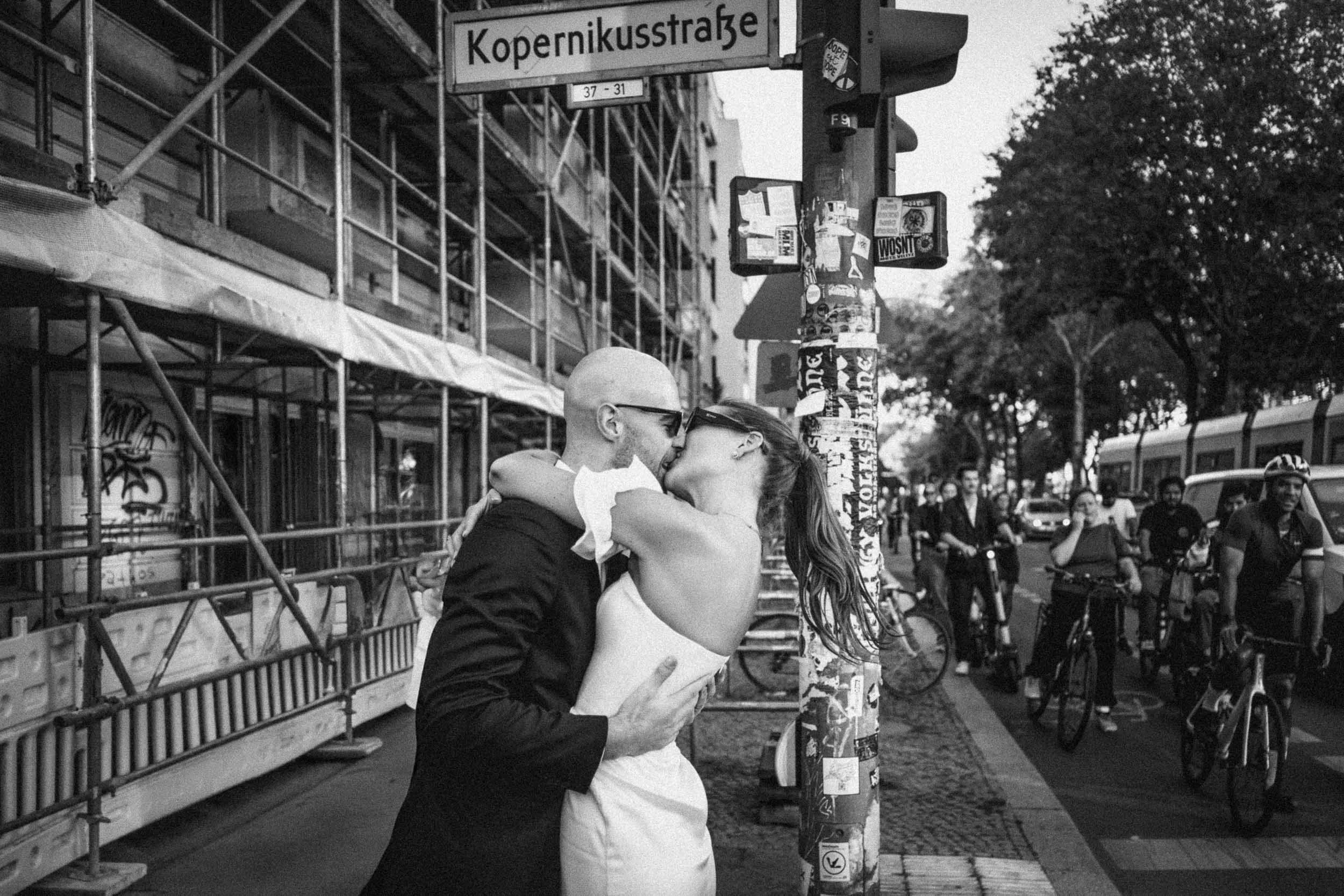 Candid black and white wedding photo on a busy Berlin street – modern city elopement captured by Studio Aelina